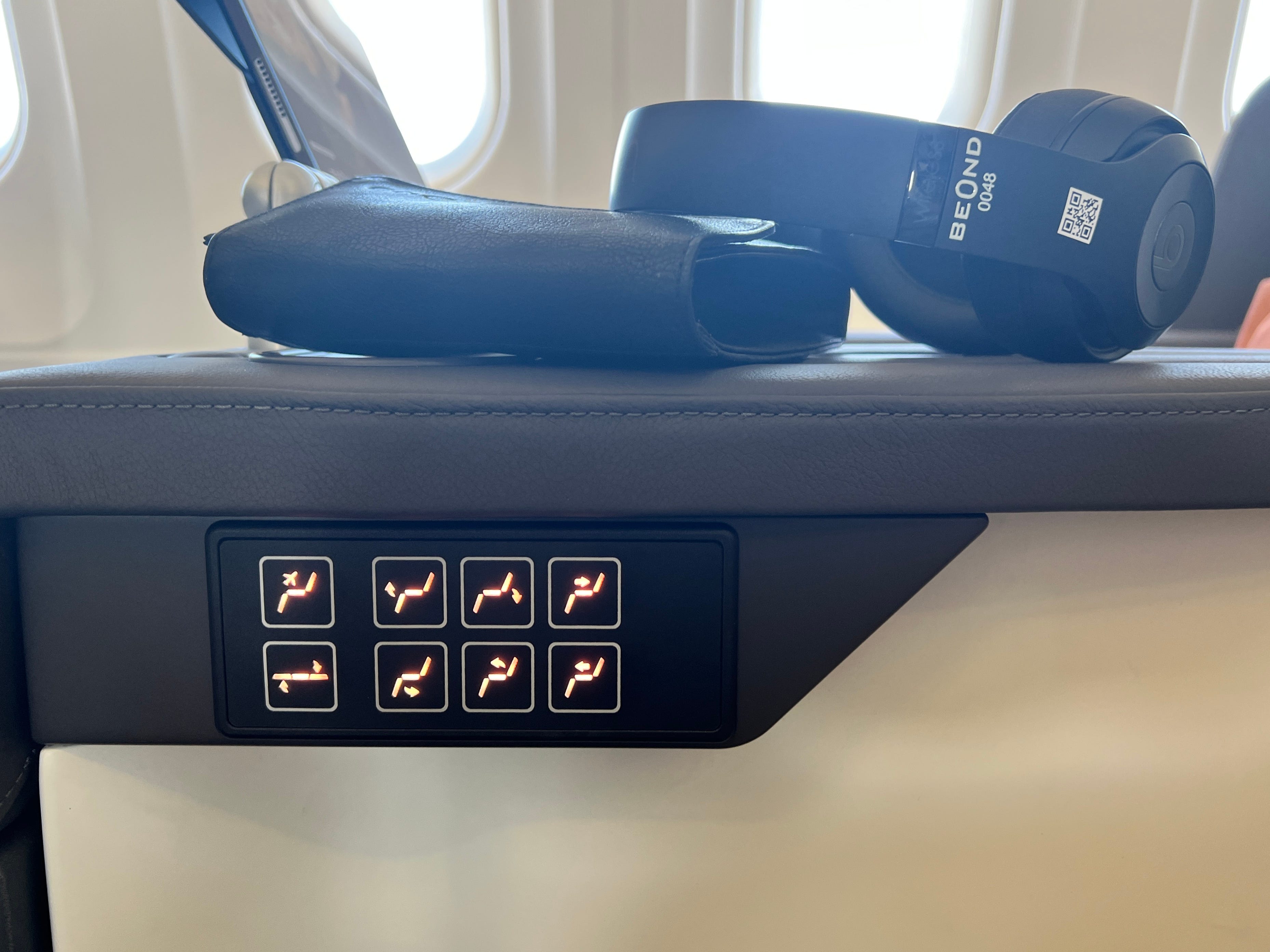 Acht schwarze Tasten mit orangefarbenen LEDs an der Armlehne eines Sitzes des Beond A319 zeigen verschiedene Optionen zur Sitzverstellung an.