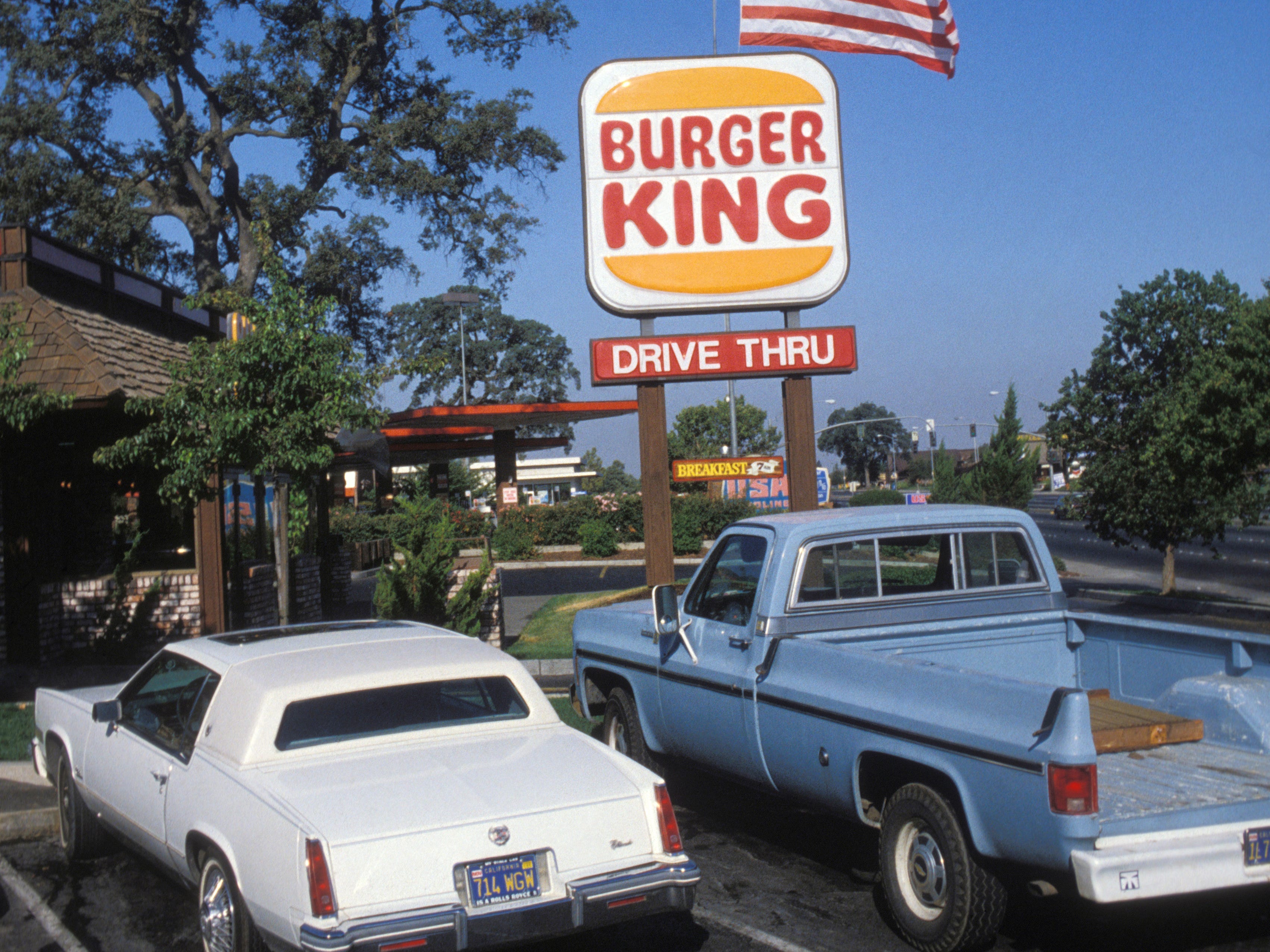 Ein Durchfahrtsschild und Autos von Burger King im Jahr 1982