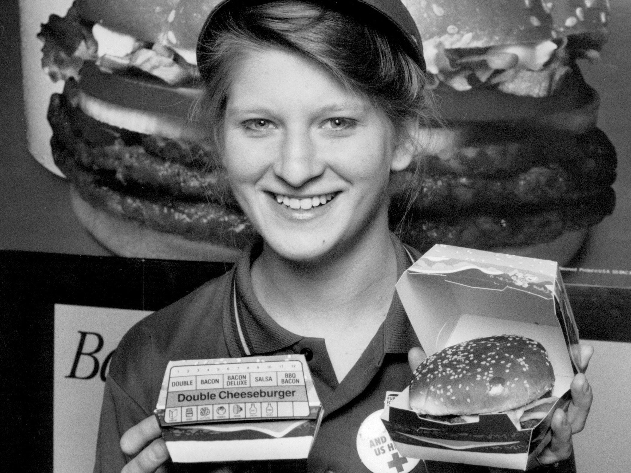 Ein Besatzungsmitglied von Burger King hält 1989 einen doppelten Cheeseburger hoch