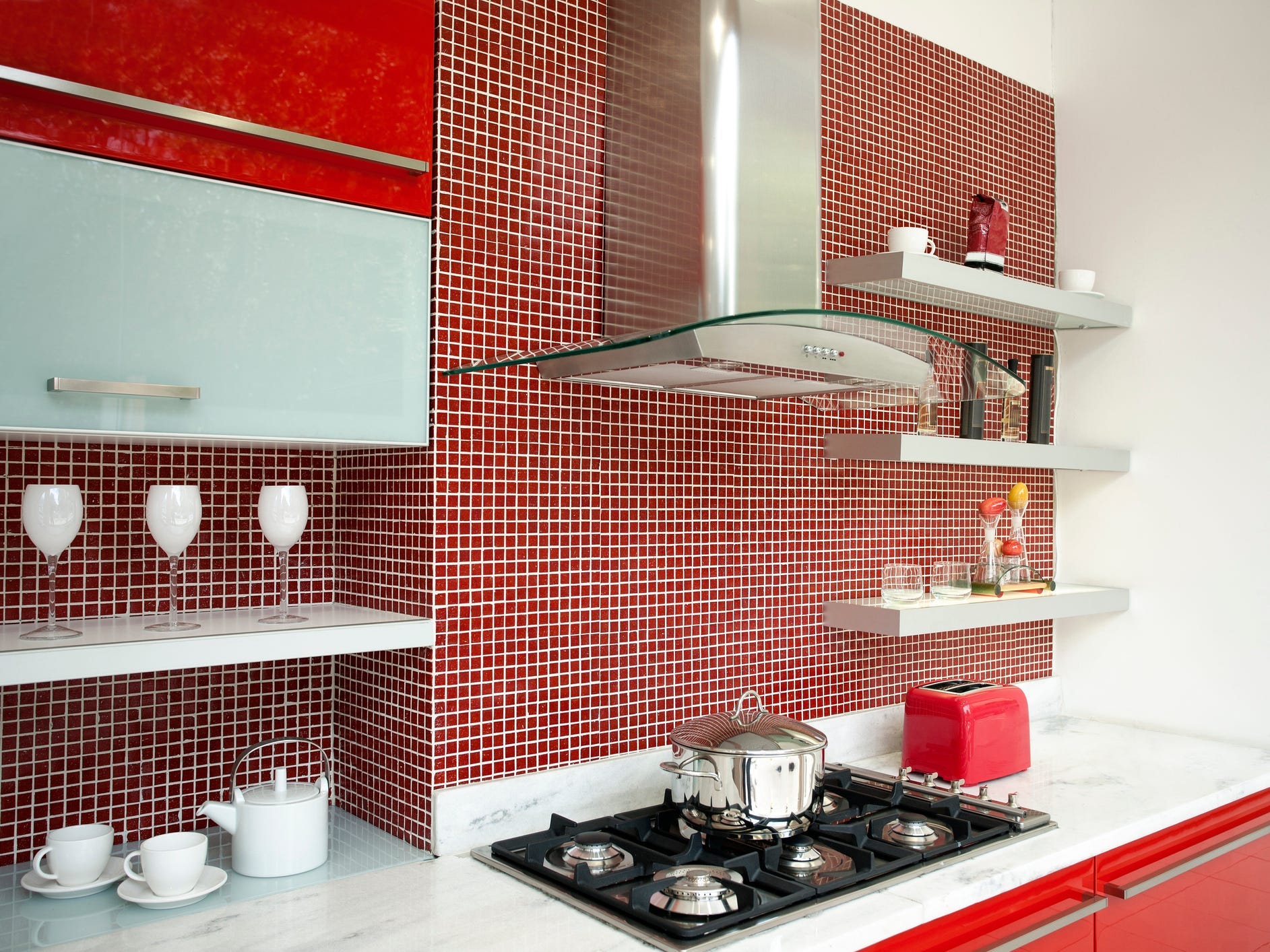 Küche mit roter Rückwand, Toaster und Schränken
