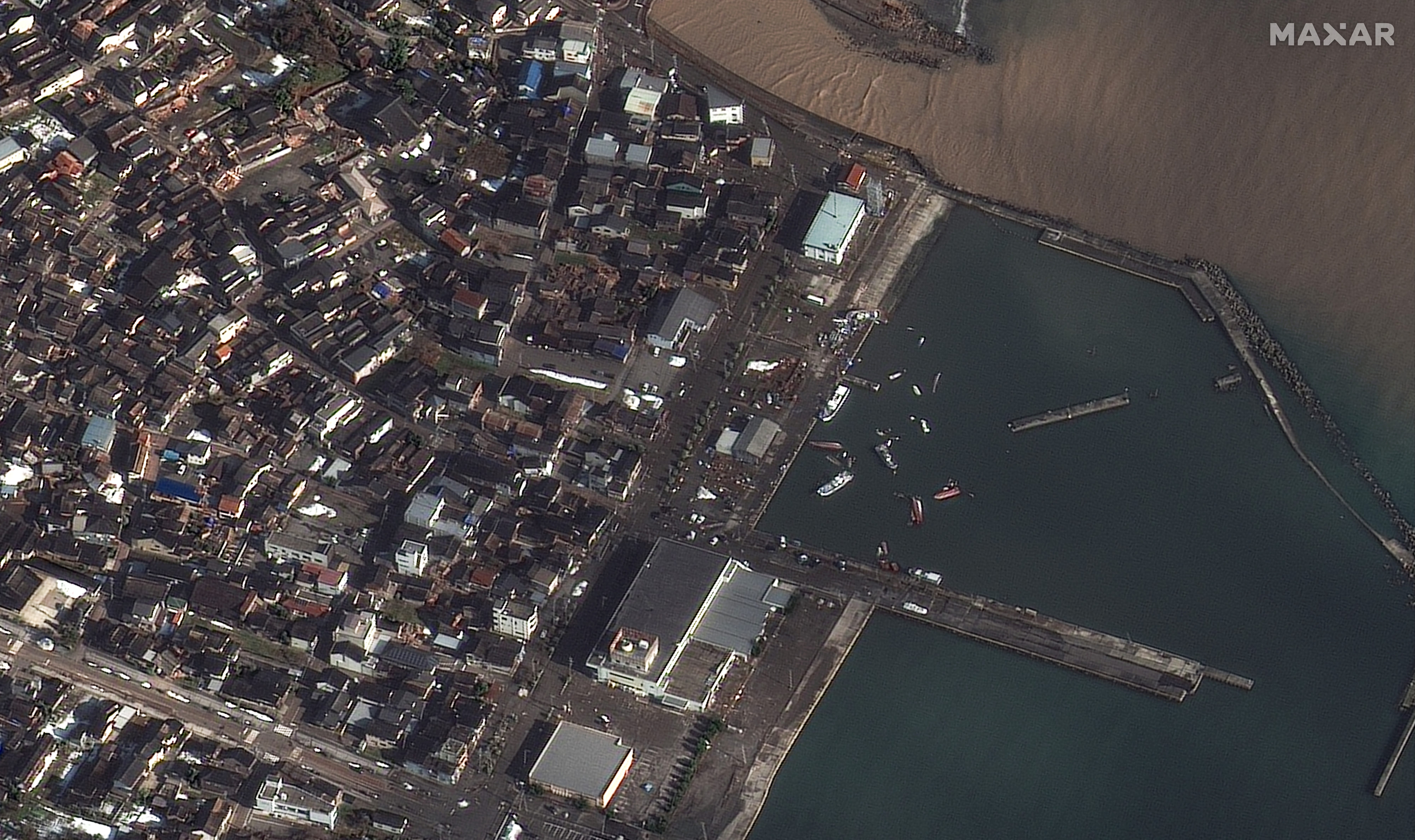 Kenterte Boote und beschädigte Gebäude in der Stadt Suzu, nachdem Japan von einem starken Erdbeben heimgesucht wurde.