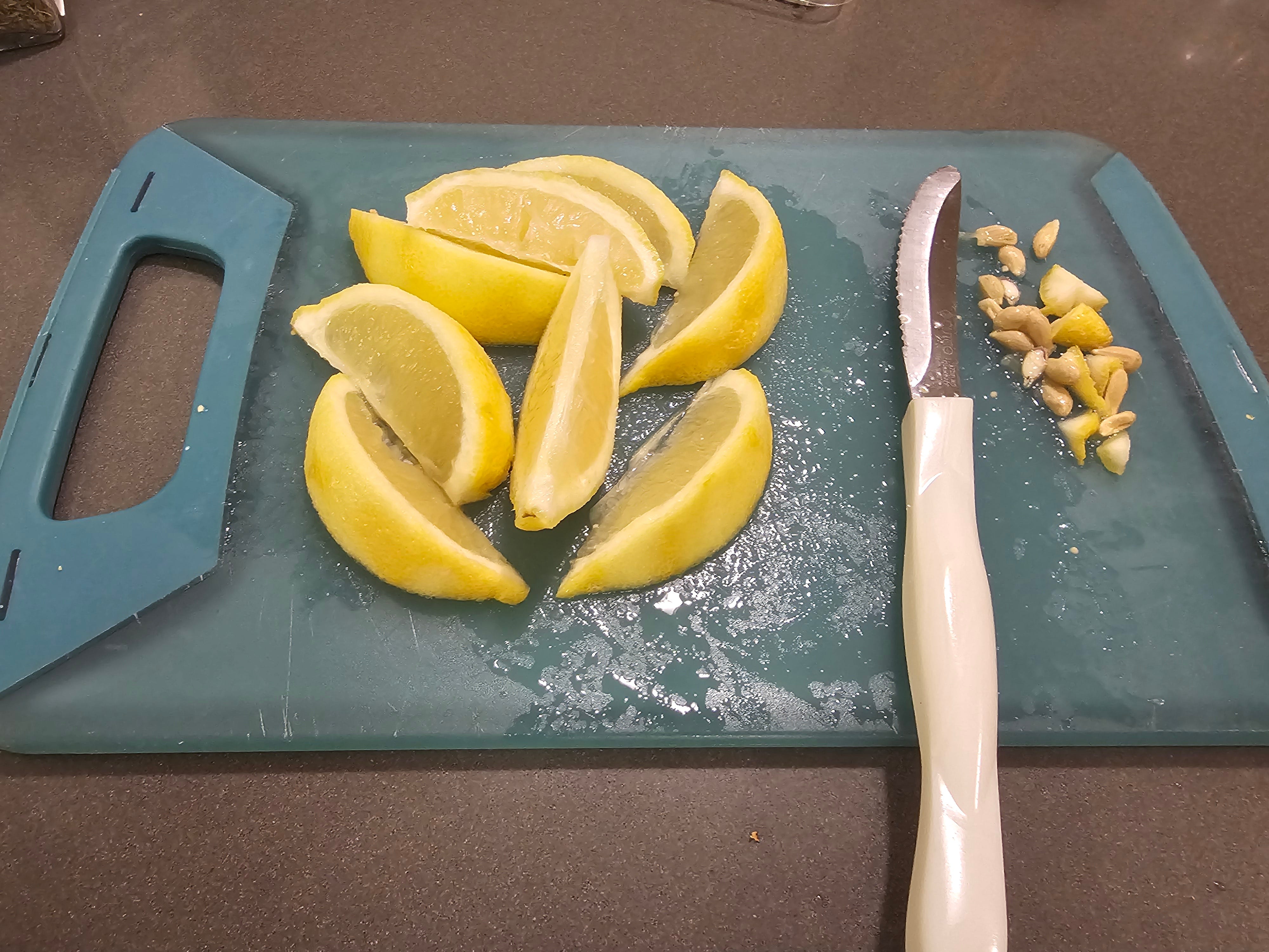 Zitronenscheiben auf einem Schneidebrett neben Messer und Samen