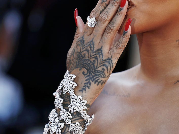 Rihanna warf den Fans auf einem roten Teppich einen Kuss zu, während sie eine kleine weiße Sonnenbrille und ein weißes Kleid trug