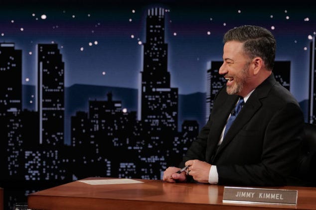 Jimmy Kimmel sitzt in seiner Talkshow an seinem Schreibtisch