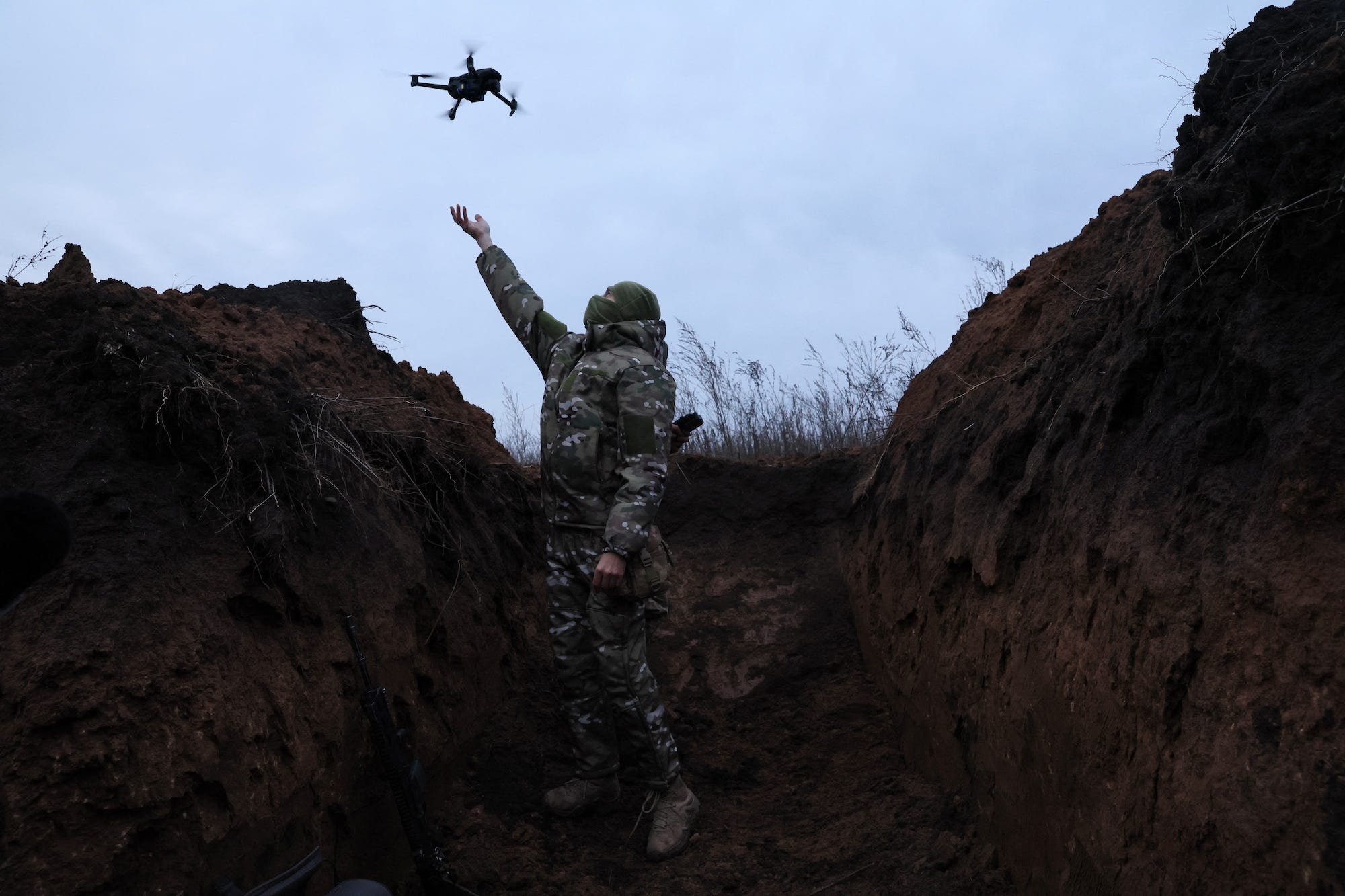 Ein Soldat der 58. unabhängigen motorisierten Infanteriebrigade der Ukraine erwischt eine Drohne, während er sie in einem Schützengraben testet
