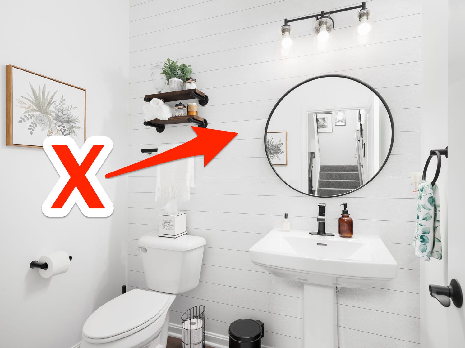 Rotes X und Pfeil, die auf eine Stufenwand in einem komplett weißen Badezimmer mit schwarzen Designelementen zeigen