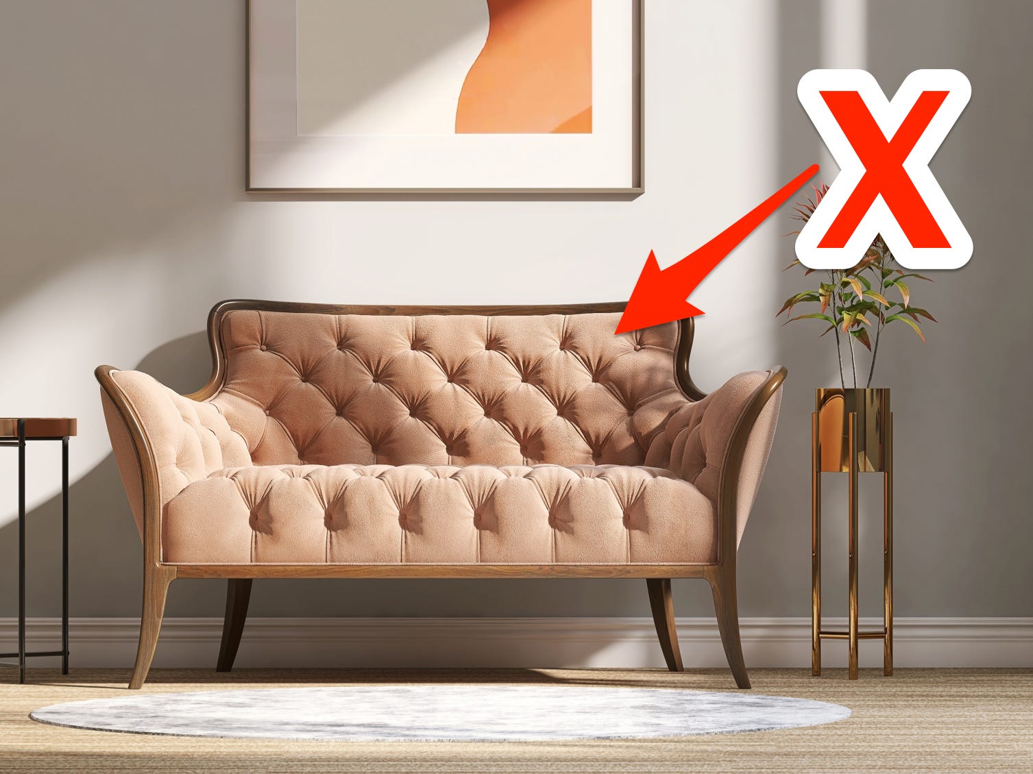 Rotes X und Pfeil zeigen auf ein pfirsichfarbenes, getuftetes Sofa in einem modernen Wohnzimmer