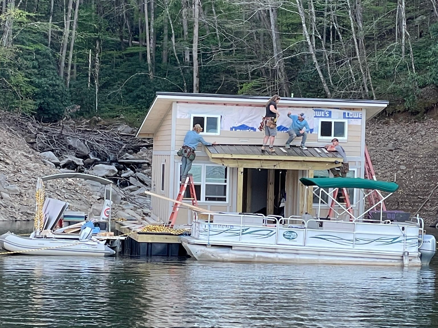 Ein paar Leute stehen während des Baus auf einem schwimmenden Haus.