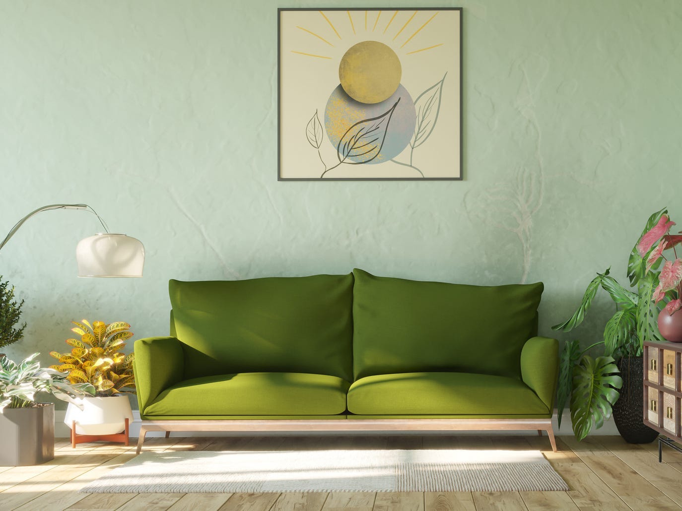 Olivgrüne Couch umgeben von Pflanzen vor mintgrüner Wand.  Über der Couch hängt ein abstrakter Kunstdruck mit einer Sonne darin