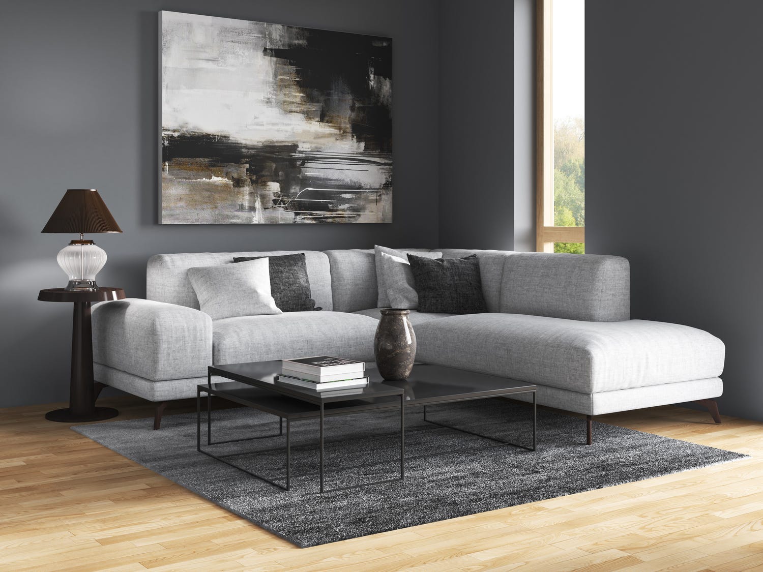 Kühlgraue Couch mit dunkelgrauen Kissen und dunkelgrauen Wänden sowie einem Teppich und einem Holzboden