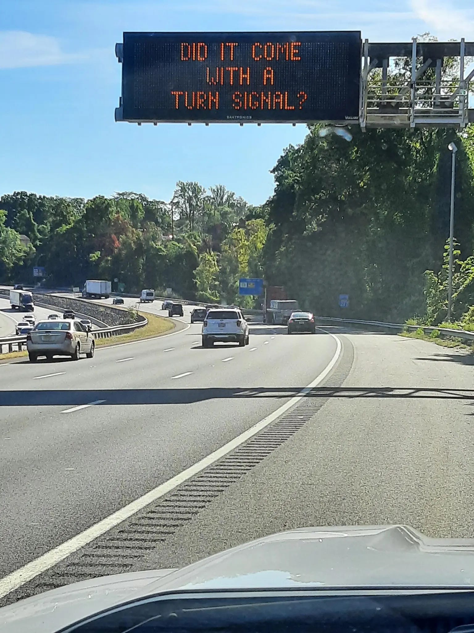 Ein Straßensicherheitsschild des New Jersey Department of Transportation mit der Aufschrift: „Schönes Auto, ist es mit einem Blinker ausgestattet?“