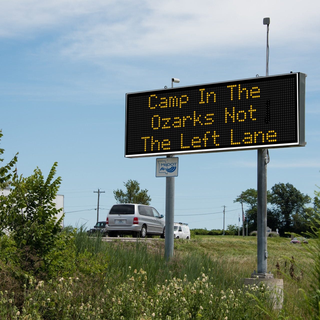 Ein Straßensicherheitsschild des Verkehrsministeriums von Missouri mit der Aufschrift „Camp in the Ozarks, nicht auf der linken Spur.“