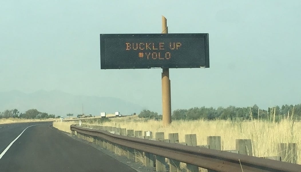 Eine Sicherheitsmeldung des Verkehrsministeriums von Utah am Straßenrand mit der Aufschrift: „Schnall dich an, #YOLO.“