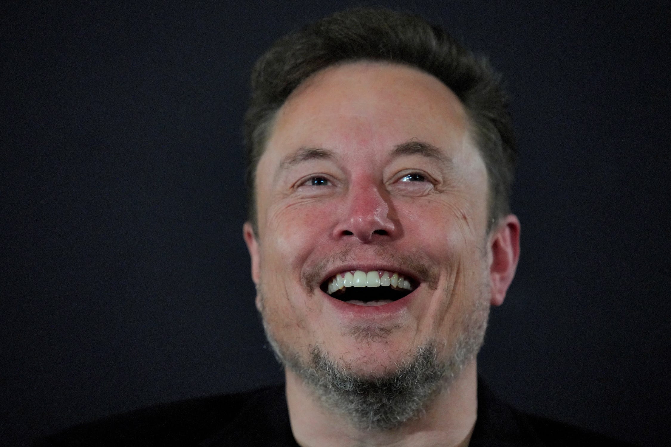 Elon Musk-Kopf lacht vor schwarzem Hintergrund