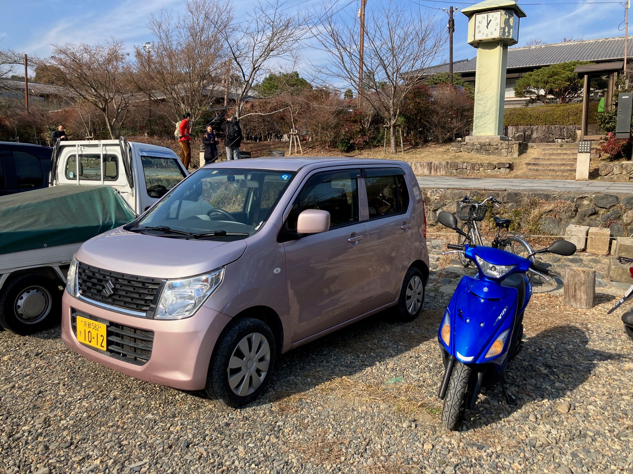 Ein Suzuki Wagon R, der in Kyoto neben einem Moped geparkt ist