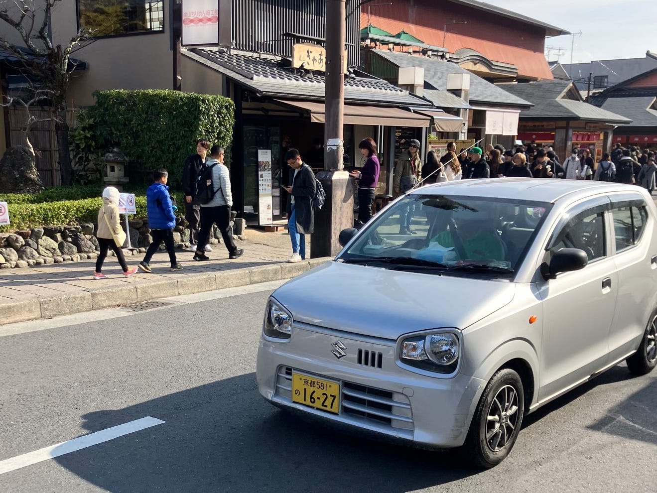 Ein Suzuki Alto auf einer stark befahrenen Straße in Japan