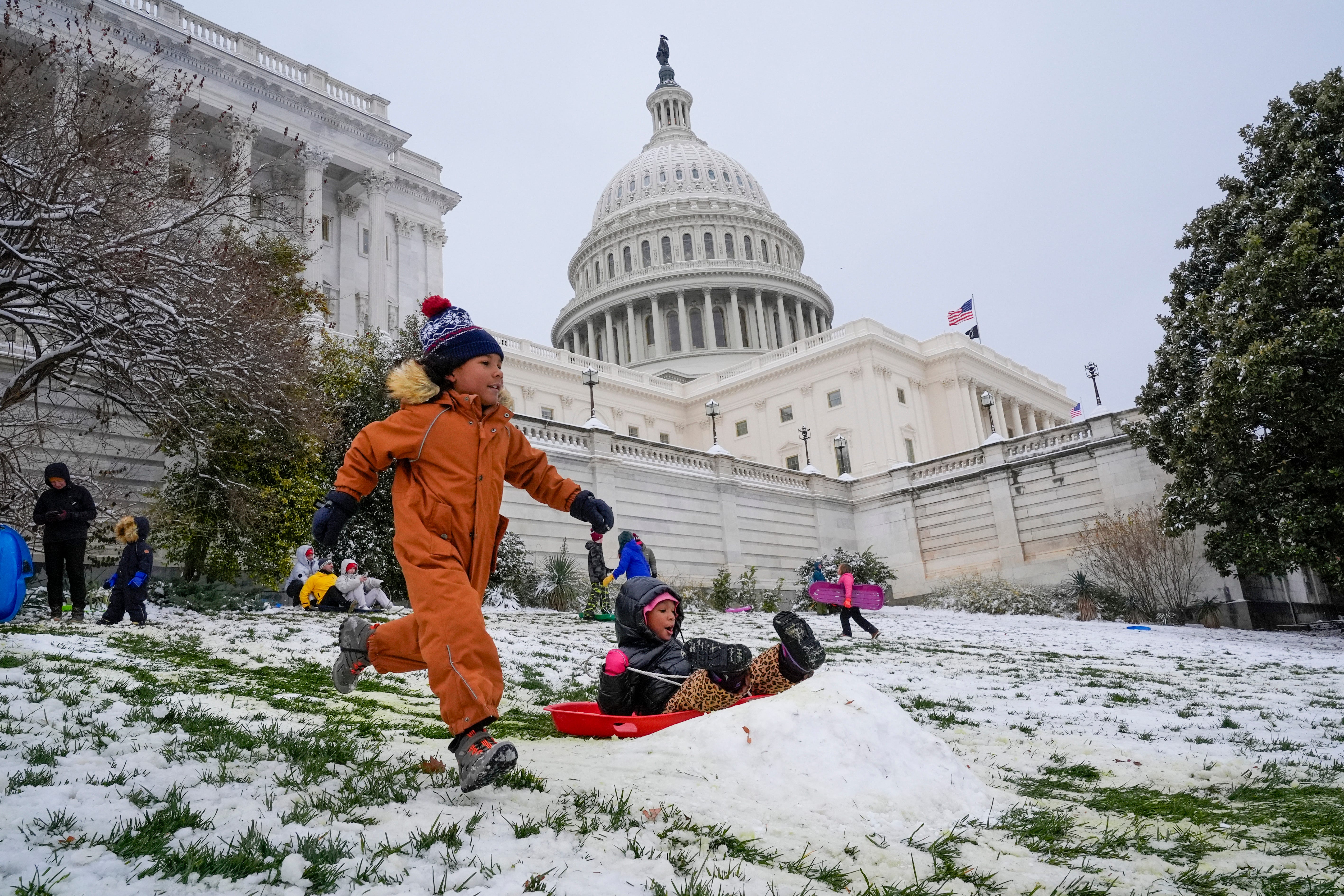 Nach einem Schneesturm, der am 16. Januar 2024 die Schulen geschlossen hat, rasen Kinder gegeneinander den Rodelhang des US-Kapitols hinunter.