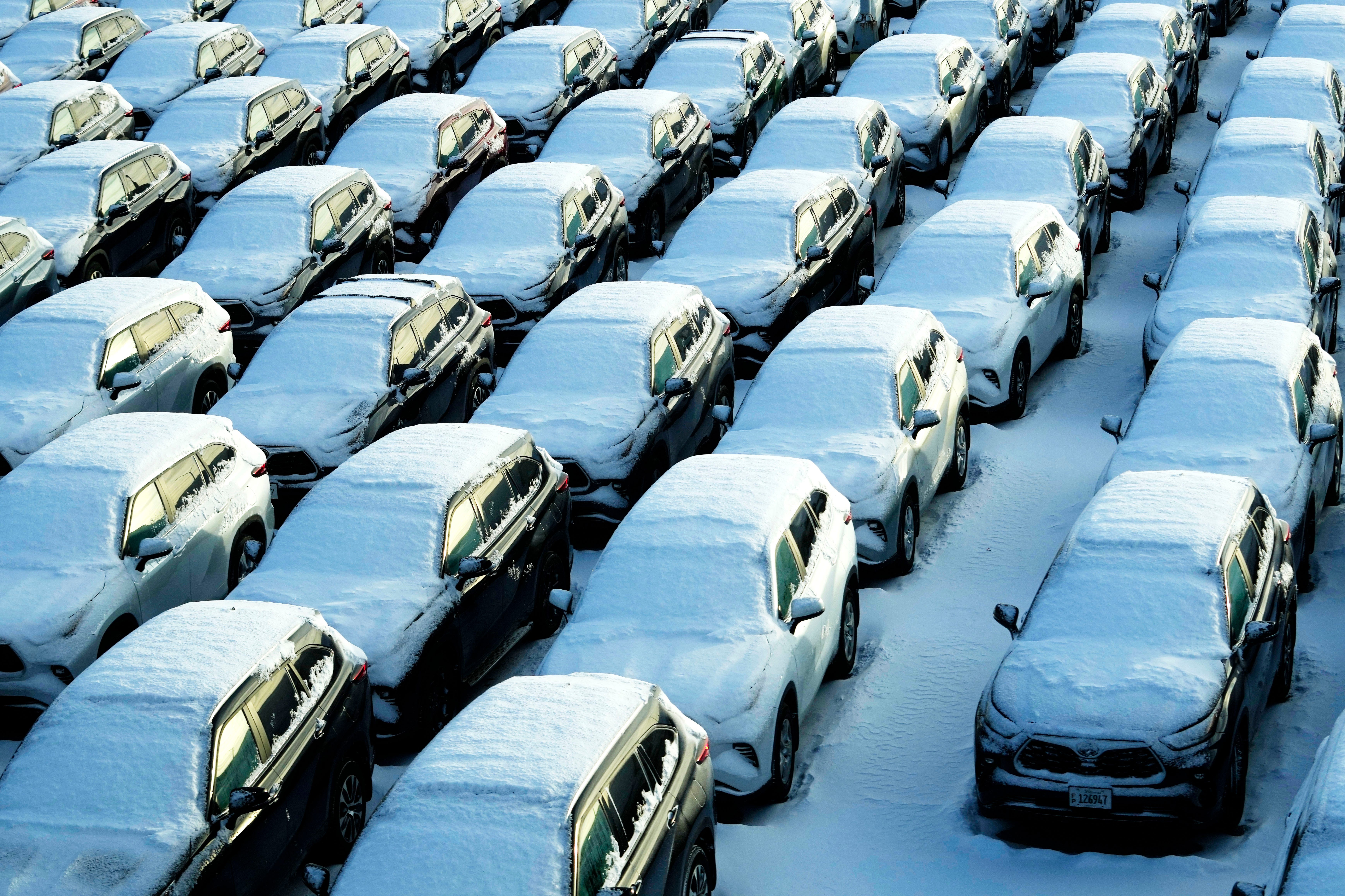 Verschneite Fahrzeuge stehen am Sonntag, 14. Januar 2024, auf einem Mietwagenparkplatz am O'Hare International Airport in Chicago.