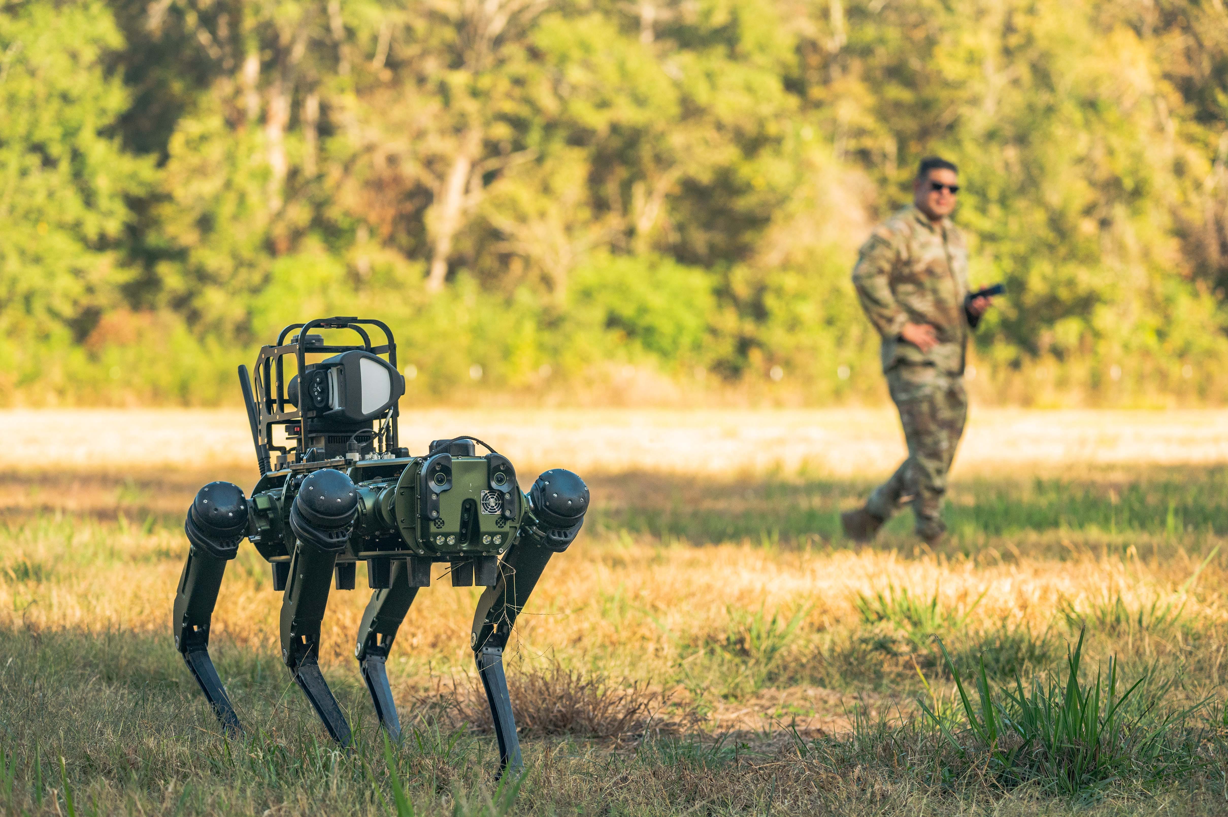 Luftwaffenmeister Sgt.  Dominic Garcia beobachtet Atom, den Roboterhund, während Teamkollegen ihn per Fernsteuerungstraining auf der Barksdale Air Force Base, La., am 6. November 2023 bedienen.