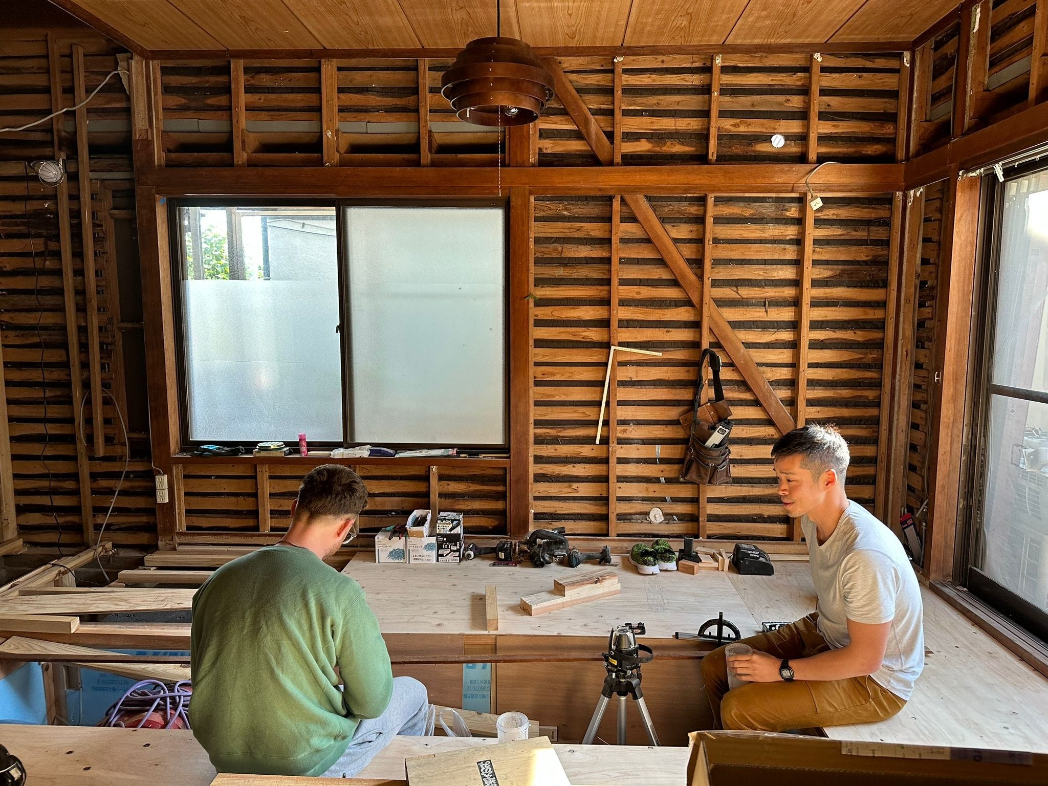 Zwei Männer sitzen mitten in einer Hausrenovierung in Japan.