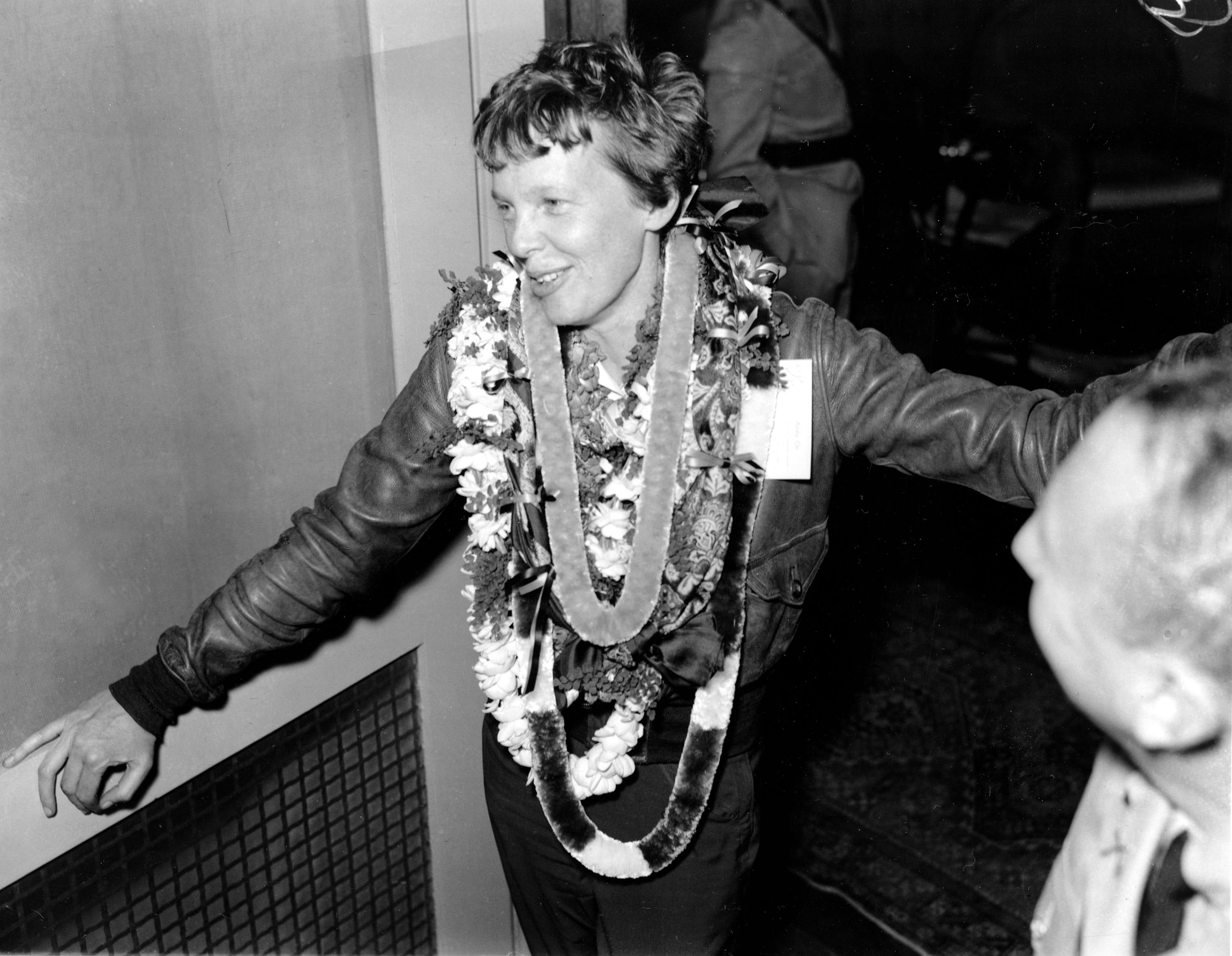 Amelia Earhart trägt nach der Landung in Honolulu, Hawaii, eine Kette aus Blumenketten um den Hals.