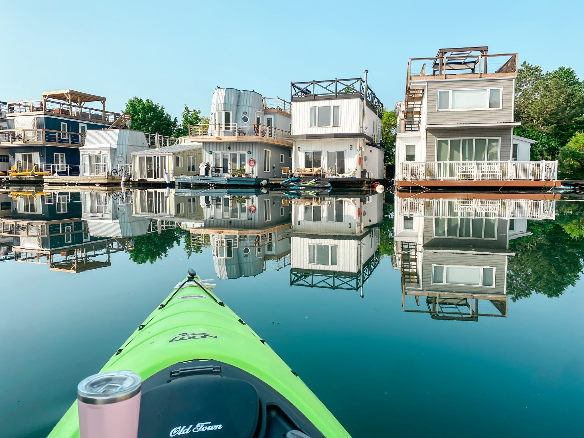 Schwimmende Häuser und Hausboote in einem Yachthafen.