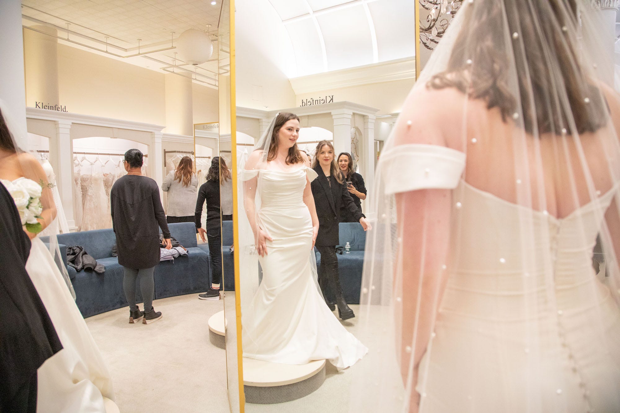 Eine Frau in einem Hochzeitskleid betrachtet sich im Spiegel.