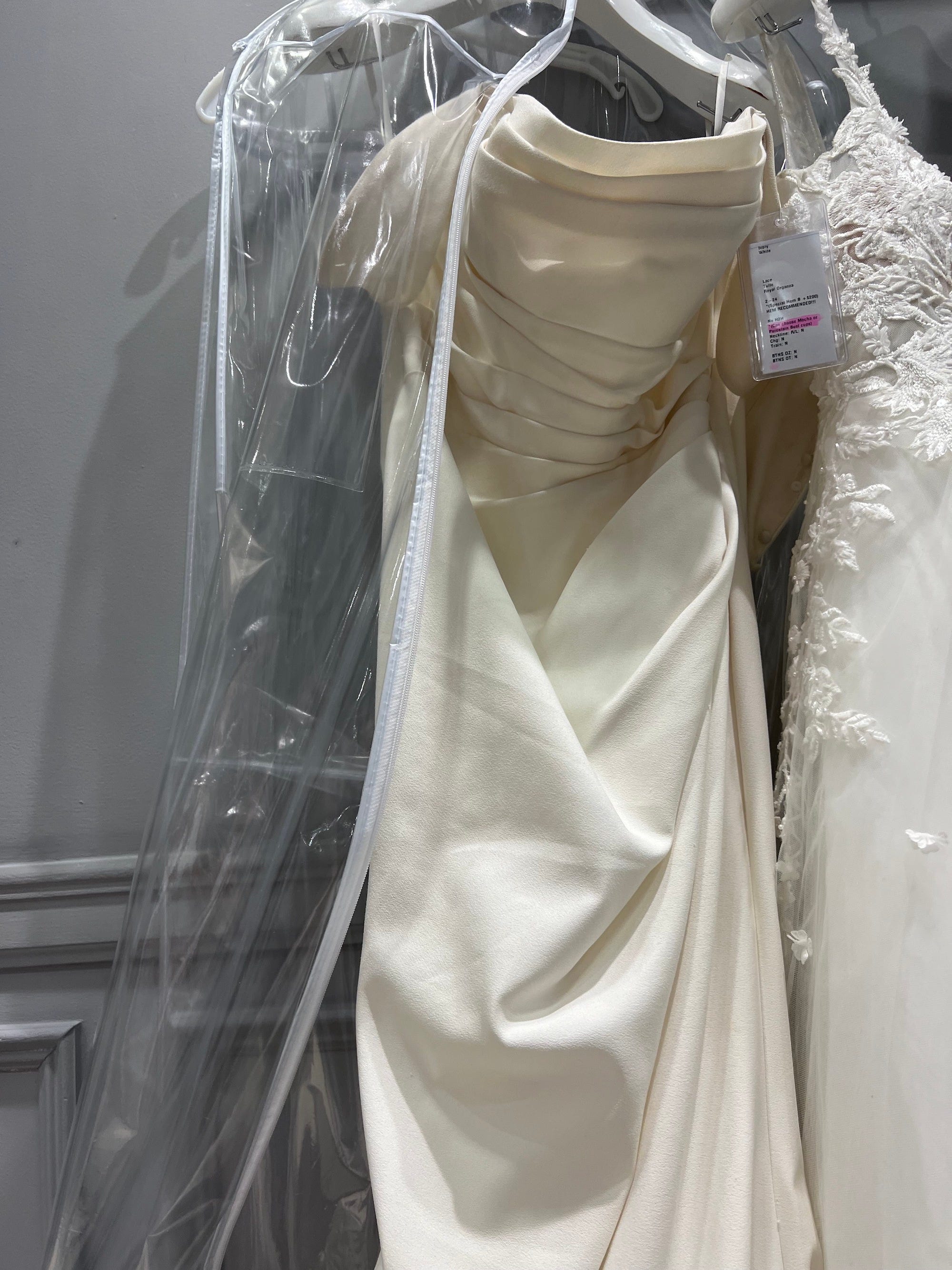 Ein Hochzeitskleid hängt auf einem Kleiderbügel.