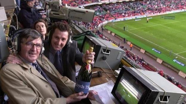 Bill McLarren und Jonathan Davies halten eine Flasche Champagner in der Hand