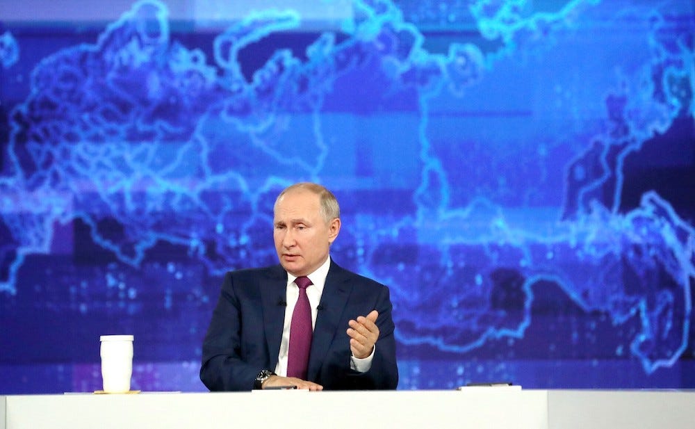 Ein Handzettelbild zeigt Präsident Wladimir Putin, wie er mit einer Hand vor einer blauen, stilisierten Weltkarte sitzt und gestikuliert, während er am 30. Juni an einem jährlichen im Fernsehen übertragenen Telefongespräch mit den Bürgern des Landes teilnimmt, das den Titel „Direkter Draht zu Wladimir Putin“ trägt , 2021.