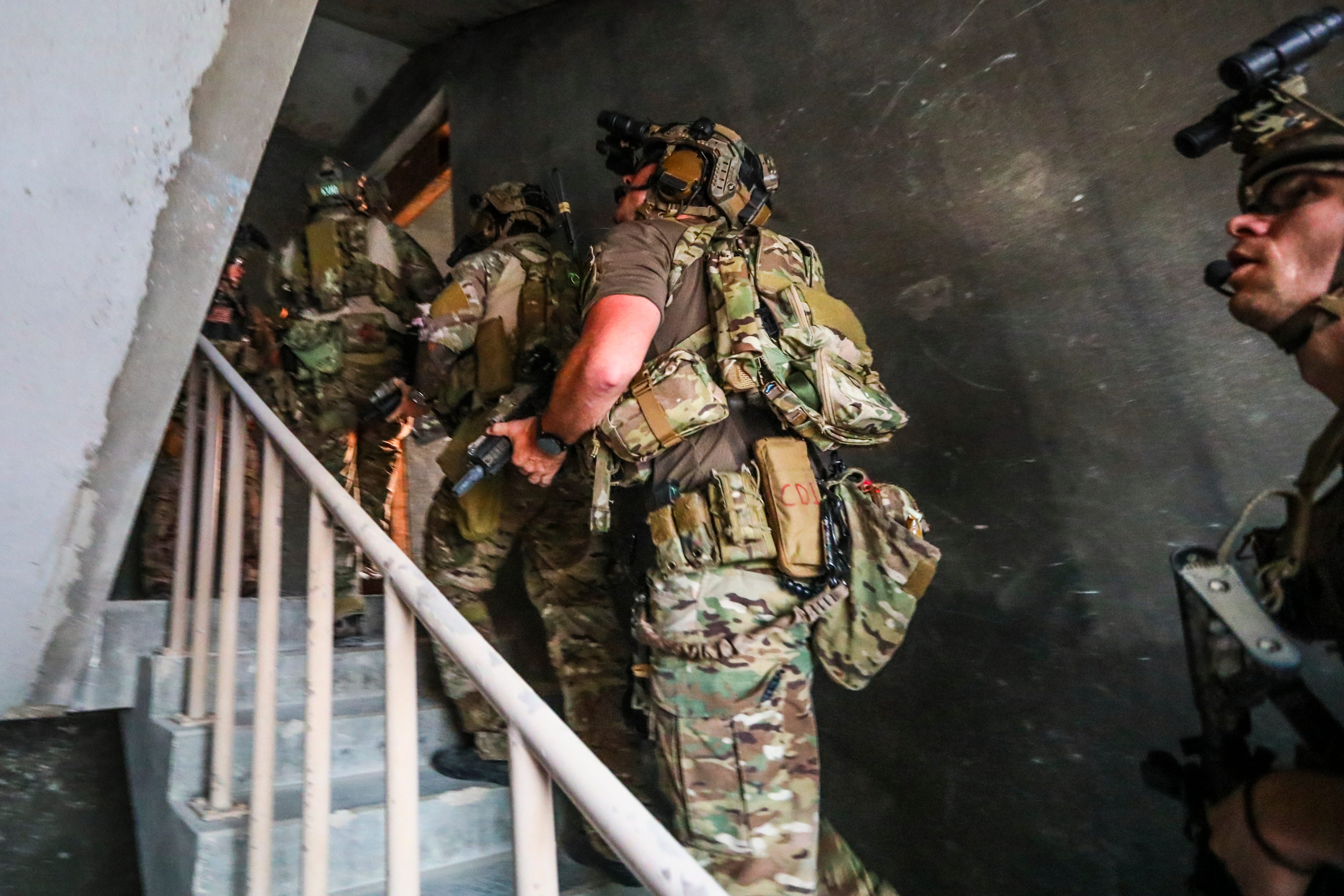 Green Berets manövrieren mit der 5. Special Forces Group (Airborne) durch ein Gebäude, während sie Räume räumen und Nahkampfübungen durchführen.
