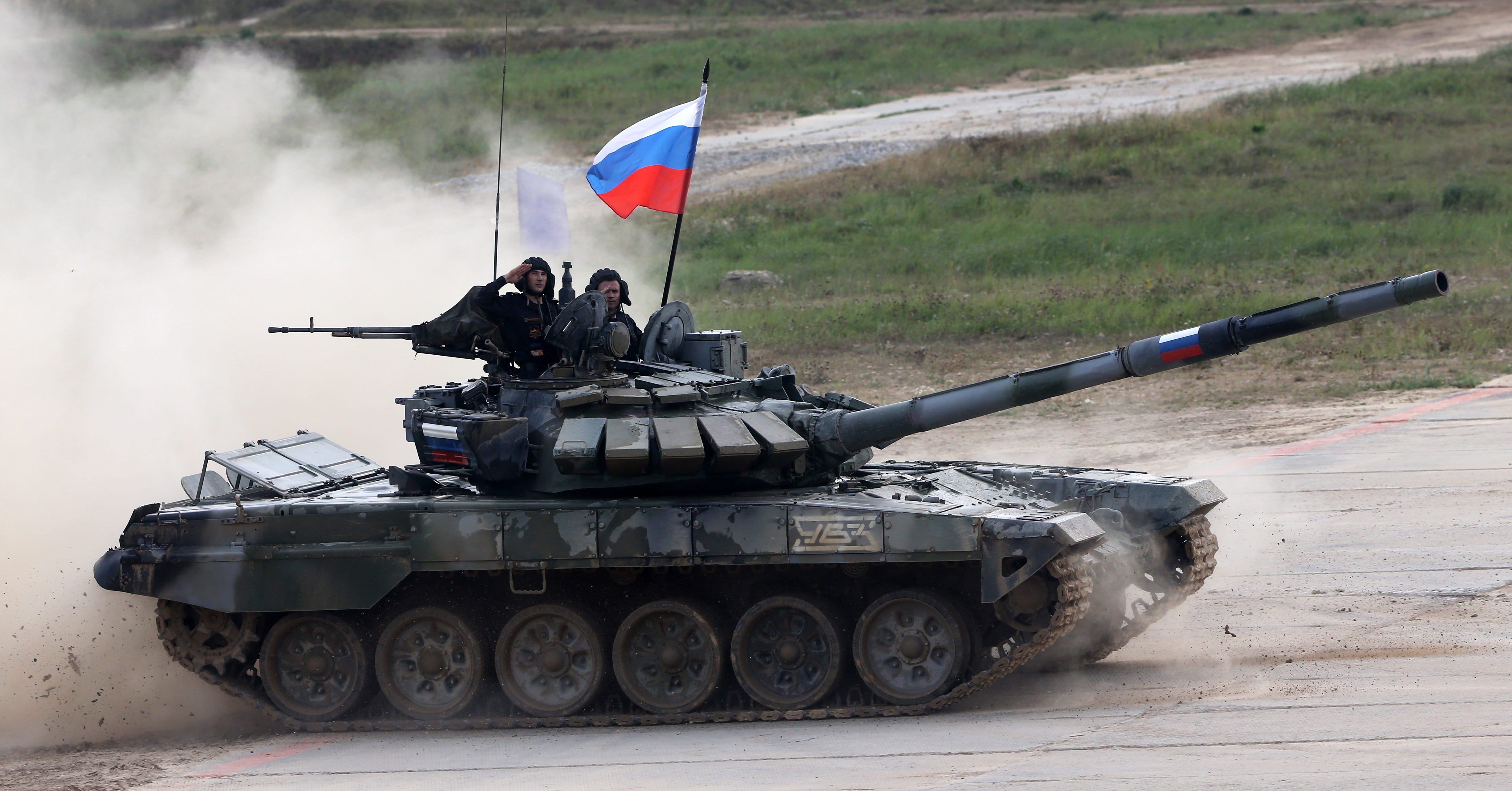 Ein Panzer mit russischer Flagge.  Das russische Team auf dem Panzer salutiert.