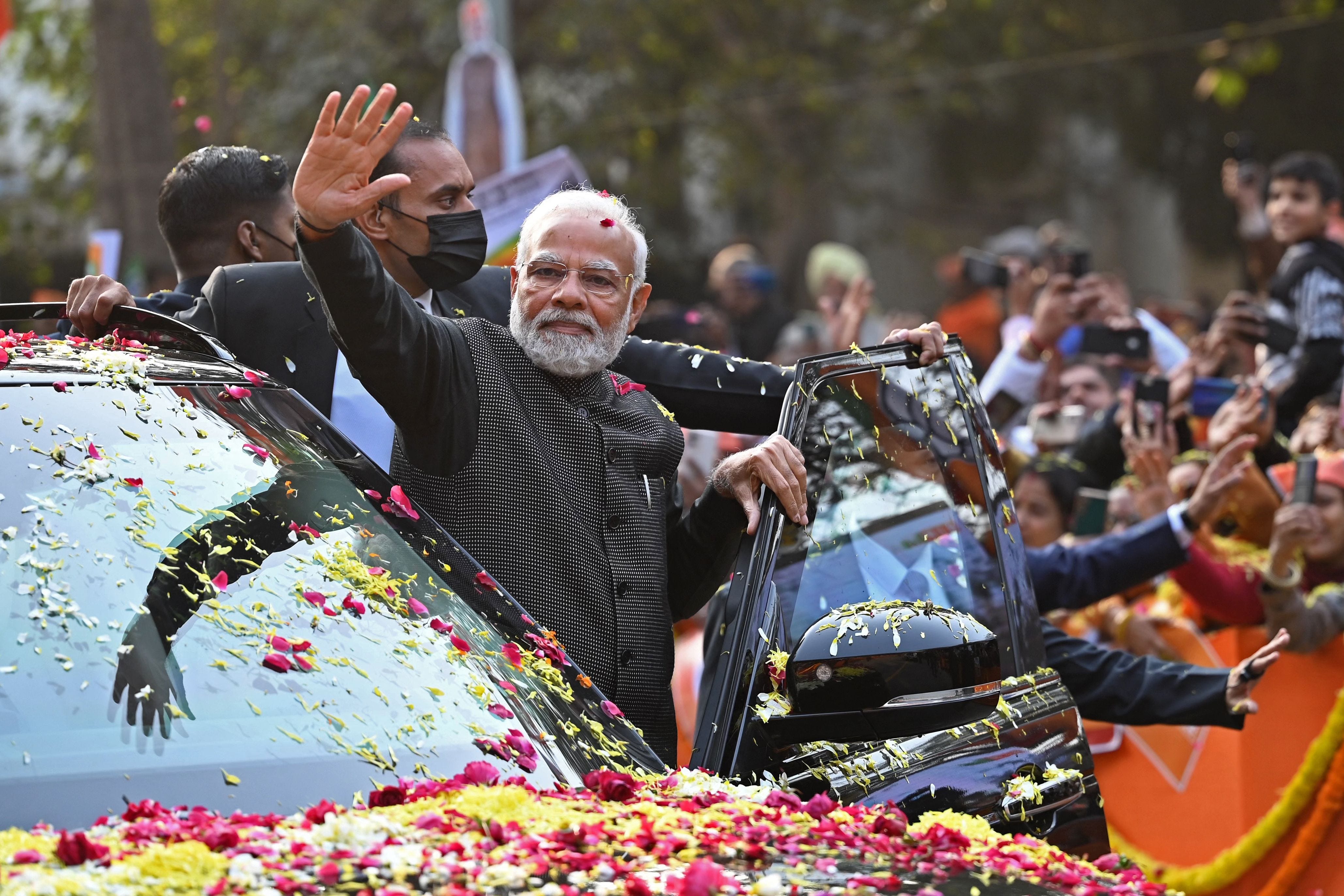 Indiens Premierminister Narendra Modi (Mitte) winkt seinen Anhängern während einer Roadshow im Vorfeld des BJP-Vorstandstreffens am 16. Januar 2023 in Neu-Delhi zu