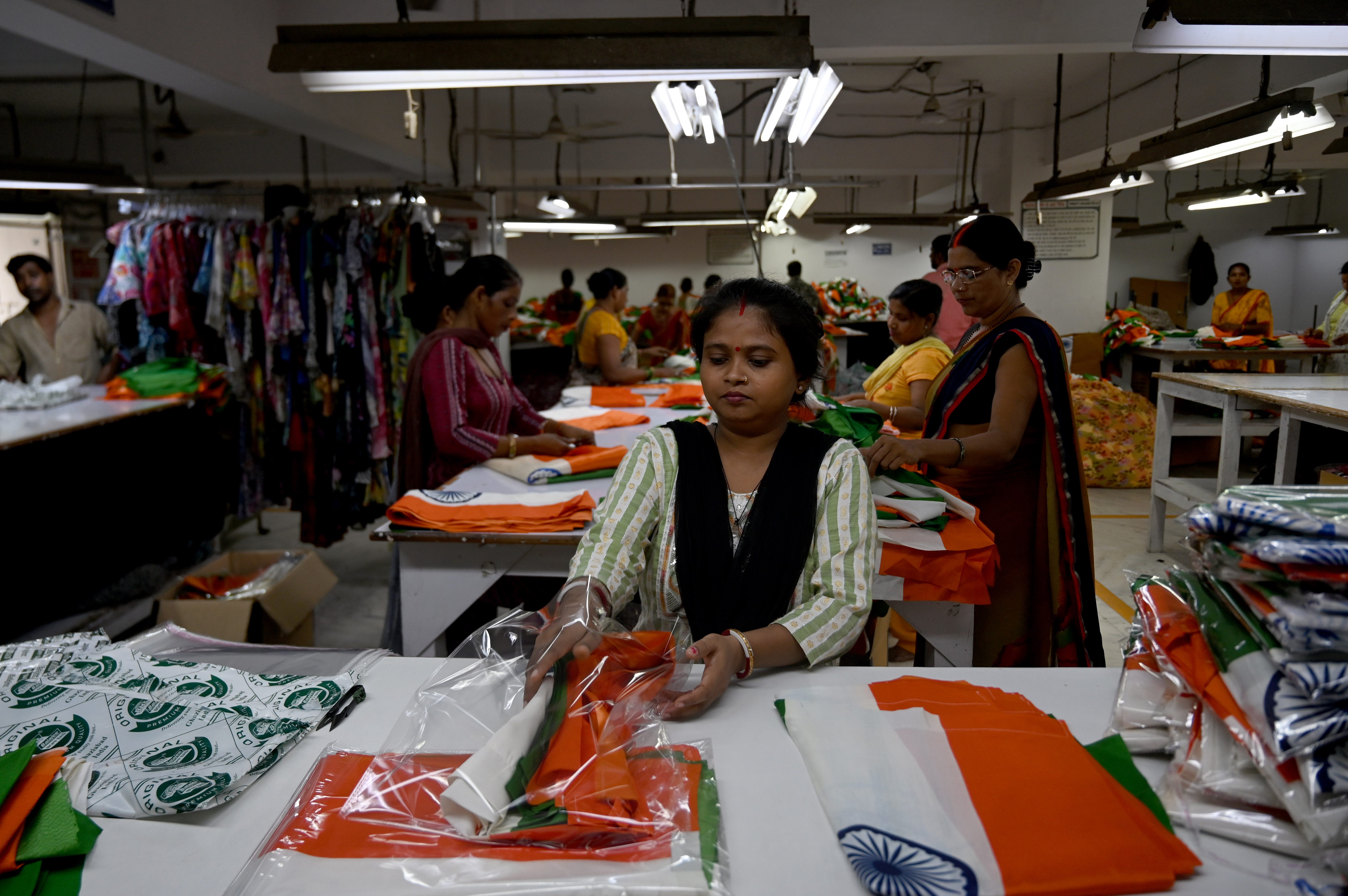 Handwerker stellen indische Trikolore in einer Fabrik im Noida-Sektor 6 her. Bekleidungsfabriken in Gautam Budh Nagar waren am 8. August 2023 im Noida Apparel Export Cluster (NAEC) in Noida, Indien, damit beschäftigt, große Mengen der indischen Nationalflagge herzustellen.