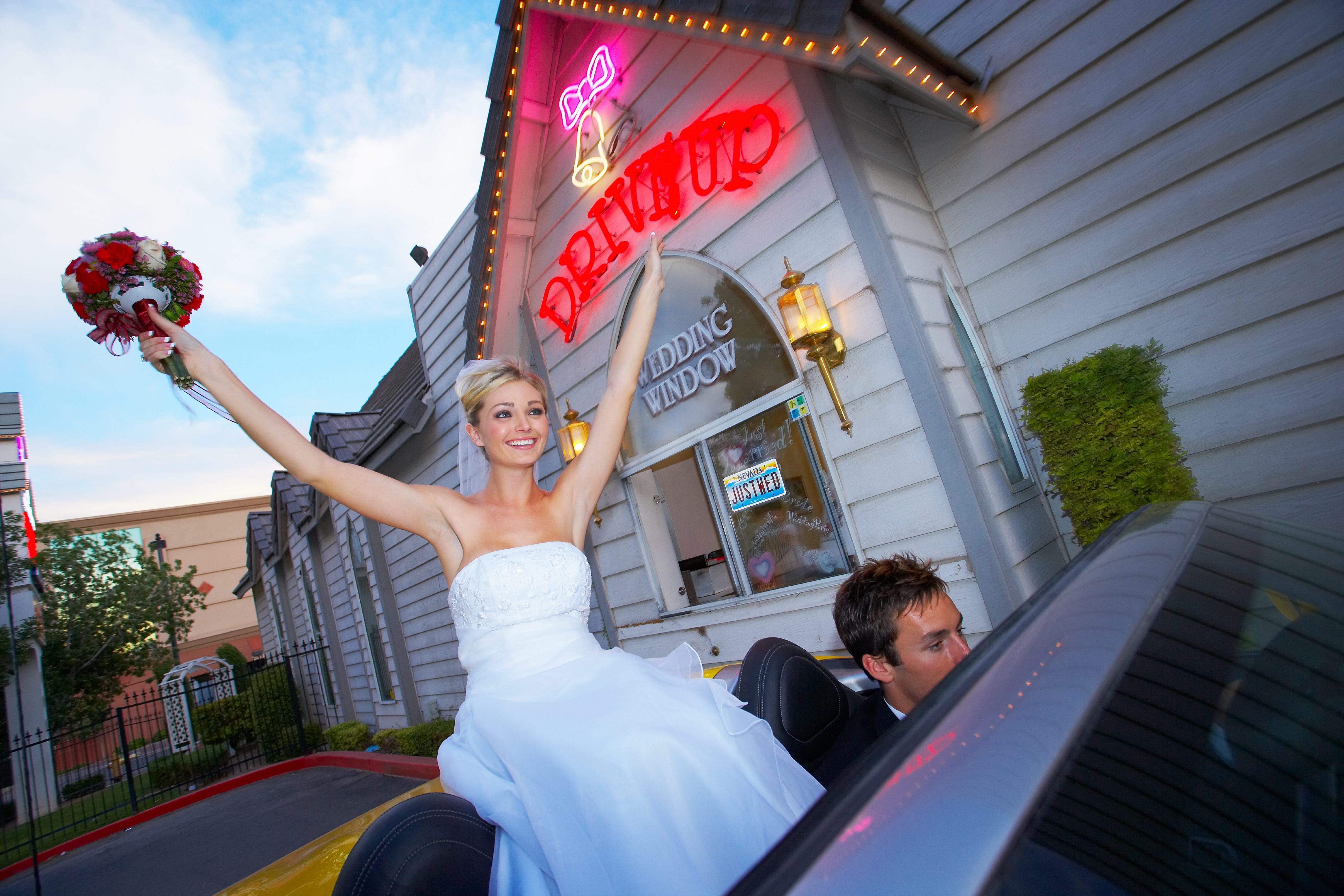 Paar heiratet und sitzt im Cabrio vor der Hochzeitskapelle.