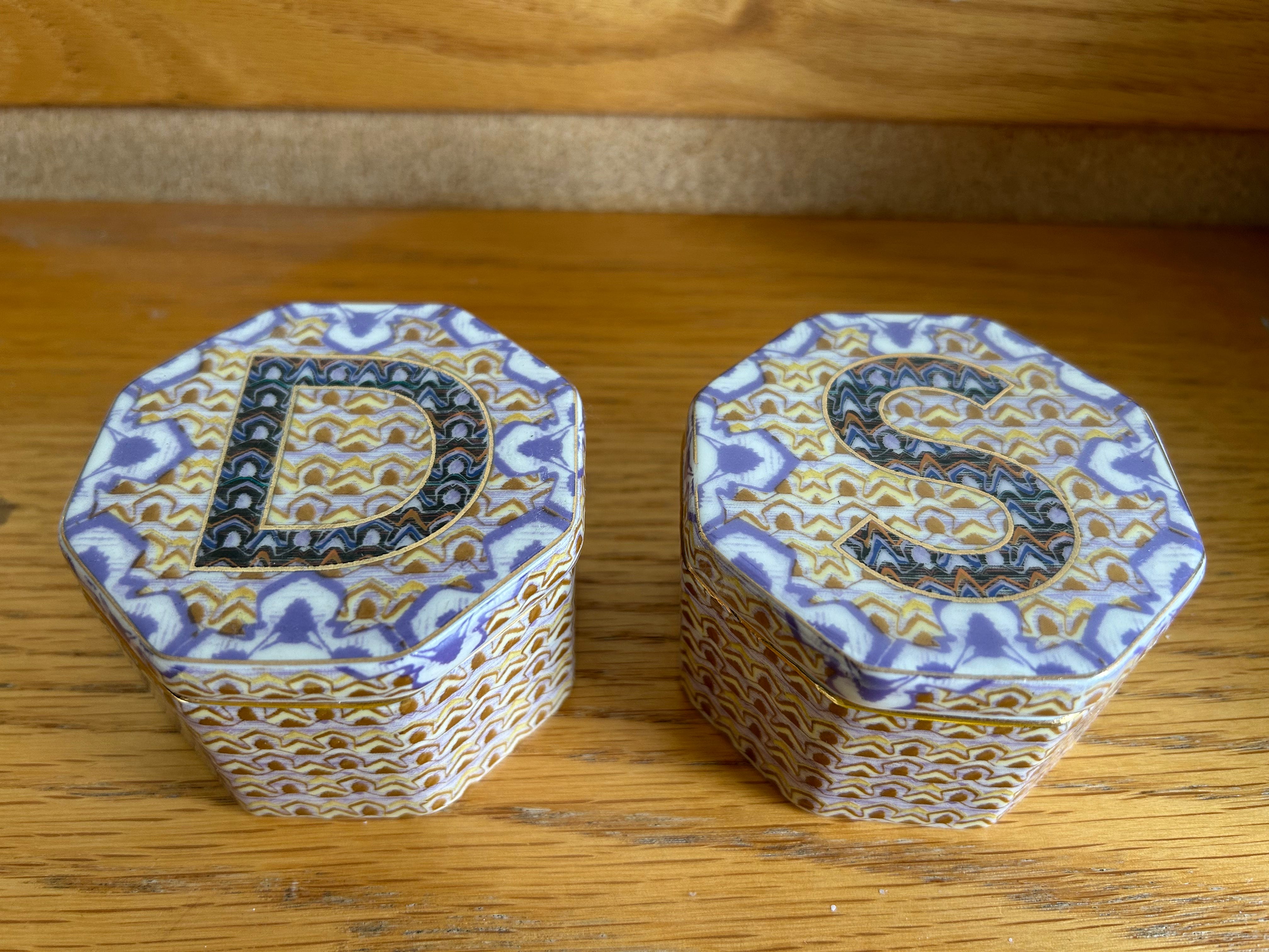 Zwei blau-goldene Mosaik-Schmuckgläser.  Auf dem einen ist ein D und auf dem Deckel des anderen ein S