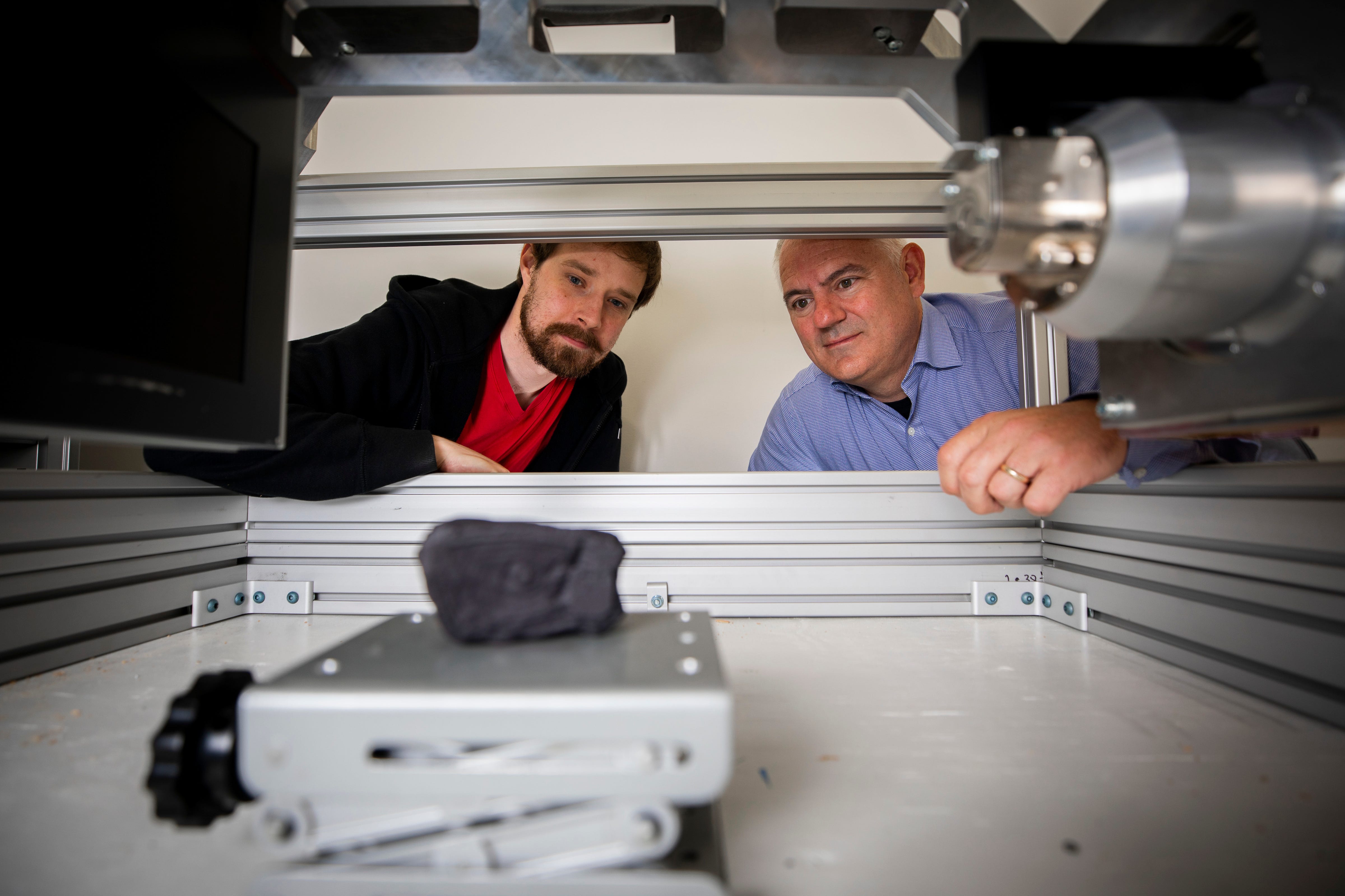 Seth Parker und Brent Seales scannen eine Nachbildung der Herculaneum-Schriftrolle in einer Maschine