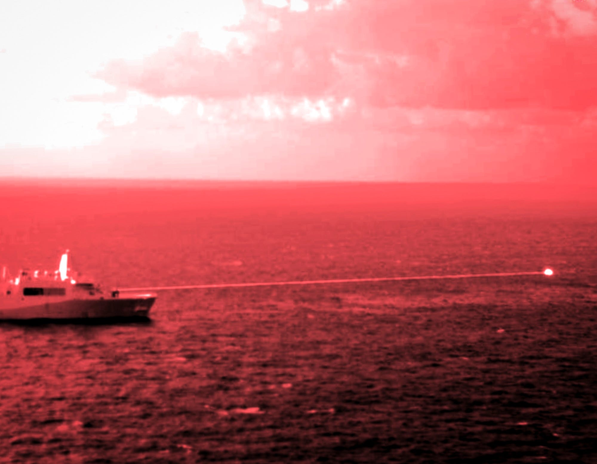 Das amphibische Transportdockschiff USS Portland feuert eine hochenergetische Laserwaffe auf ein Trainingsziel.