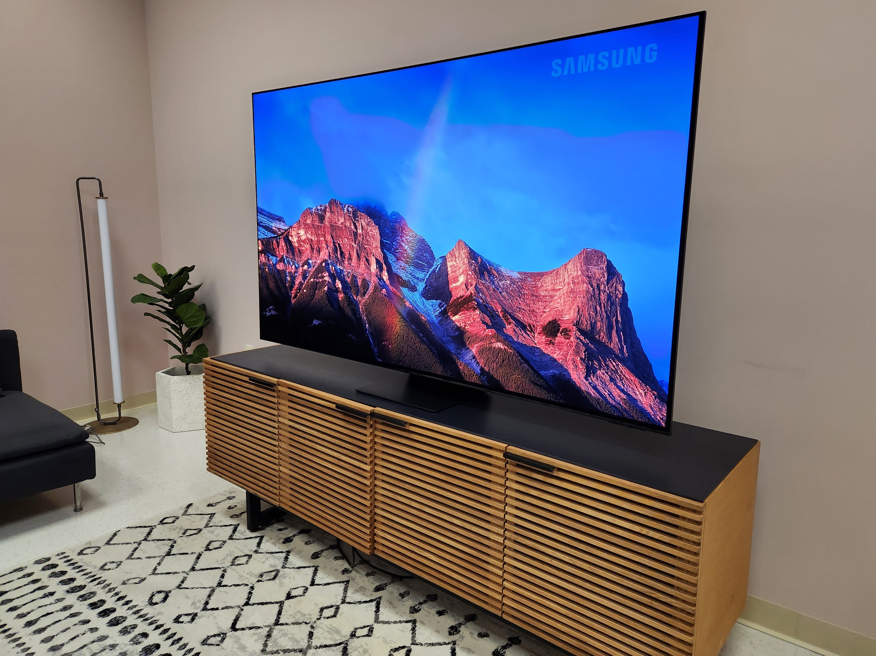 Eine Szene über einer Bergkette, angezeigt auf einem Samsung S95C-Fernseher in einem hellen Raum.