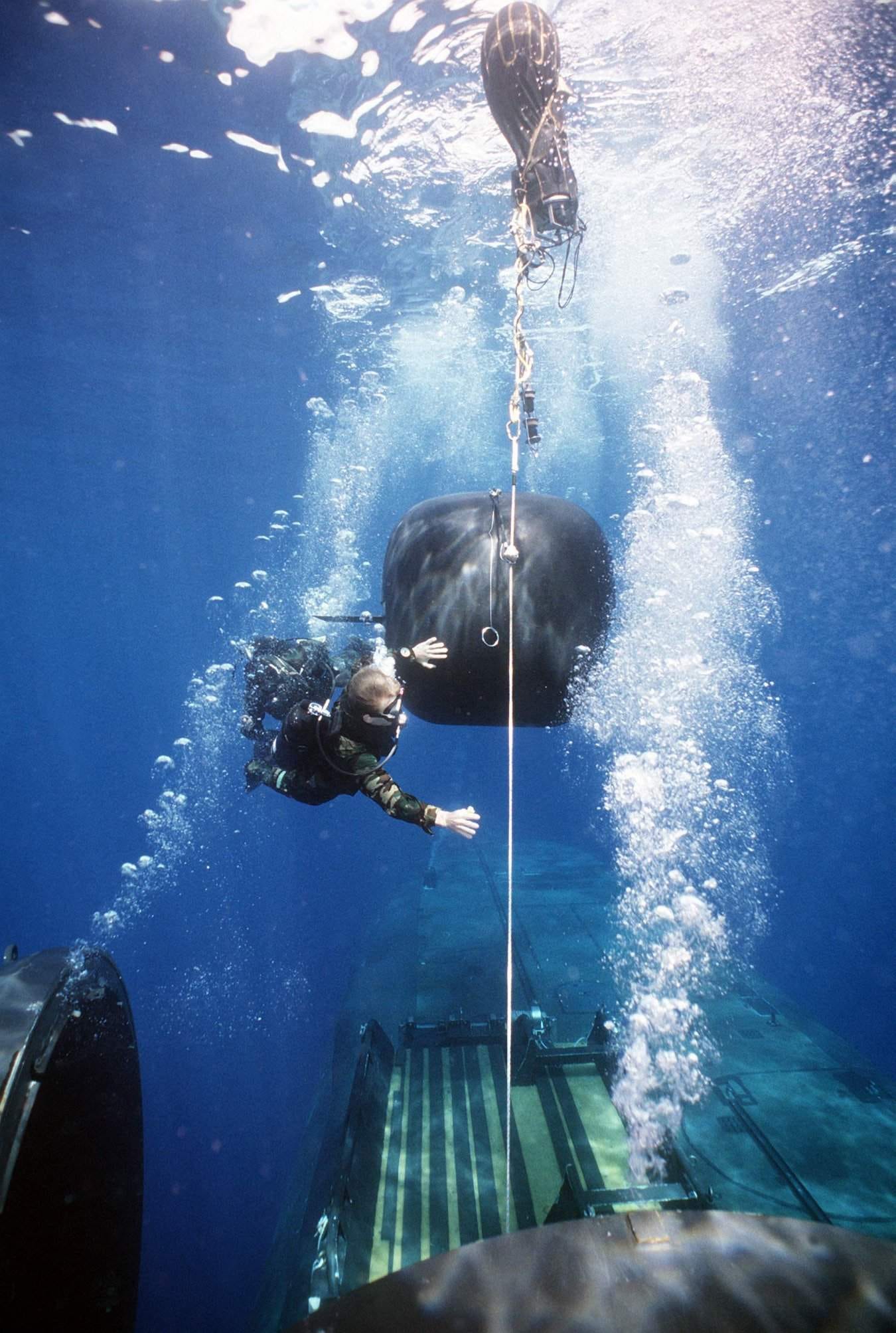Besatzungsmitglieder von Trockendeckunterkünften schwimmen an Bord des inzwischen ausgemusterten Atom-U-Boots USS Kamehameha die Halteleine zum DDS hinunter