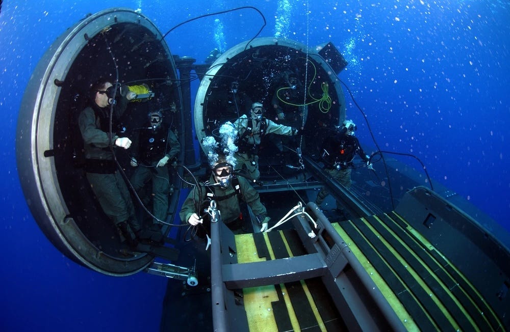 Marinetaucher und Spezialoperatoren führen SEAL-Lieferfahrzeugoperationen auf einem Lenkwaffen-U-Boot durch