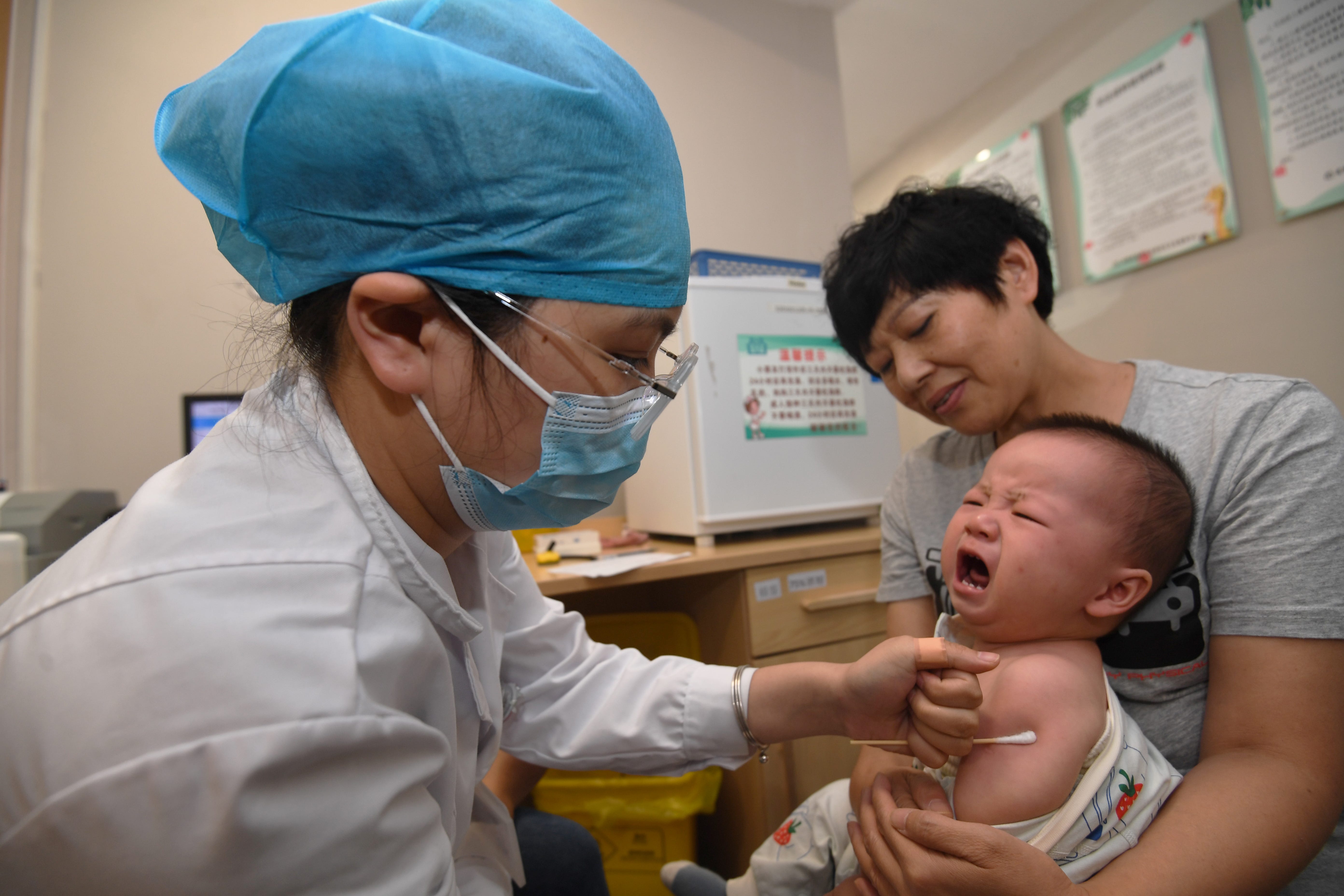 Ein medizinischer Mitarbeiter verabreicht einem Säugling einen Impfstoff.