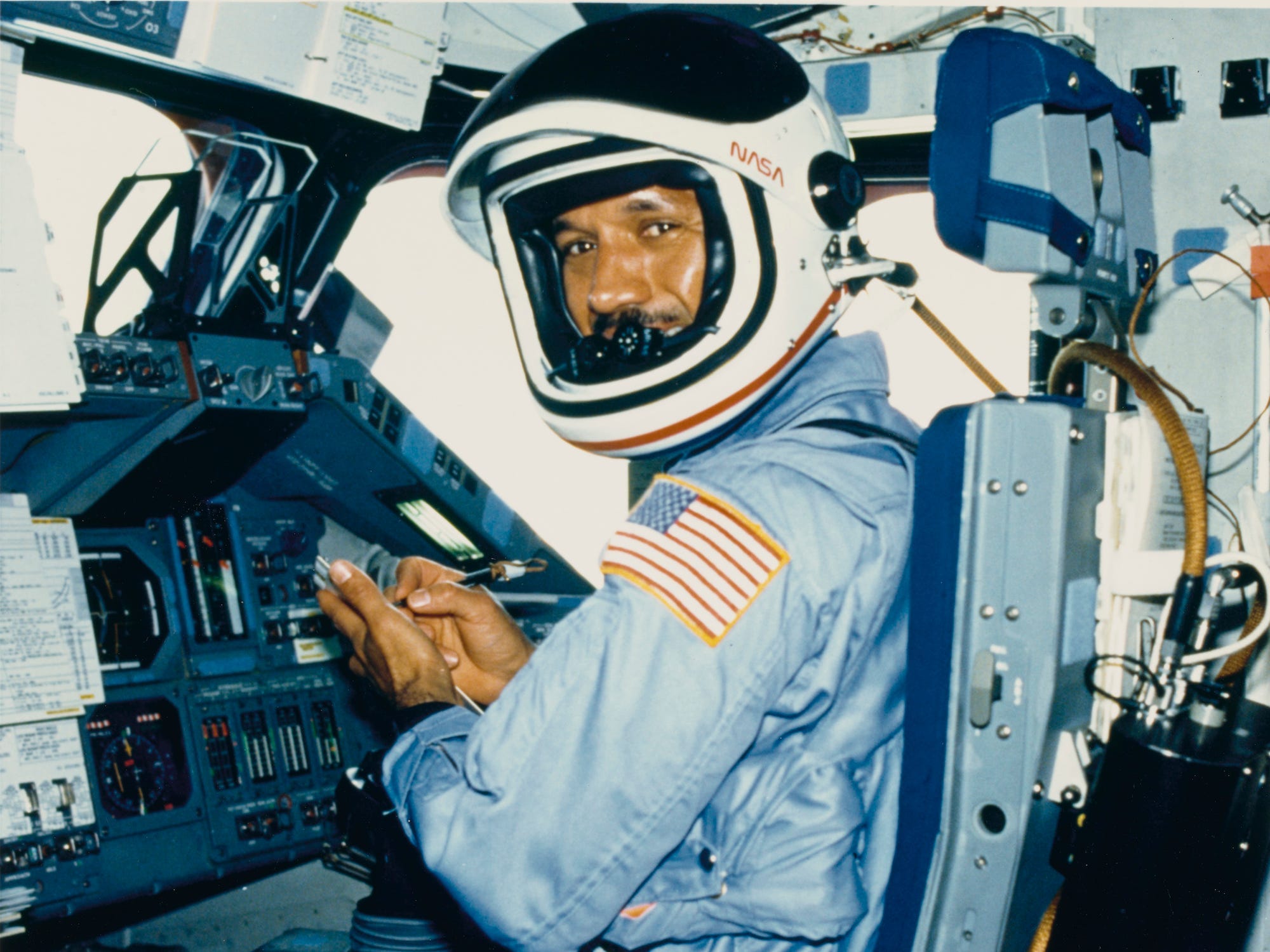 Charles Bolden trägt einen Fluganzug und einen Helm auf der Pilotenstation des Space Shuttle Columbia