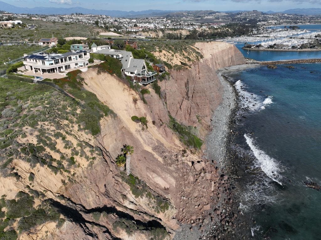 Eine Luftaufnahme von drei großen Häusern in Dana Point, die Gefahr laufen, ins Meer zu stürzen, nachdem am Wochenende nach heftigen Regenfällen in Dana Point, Kalifornien, eine Klippe nachgegeben hat