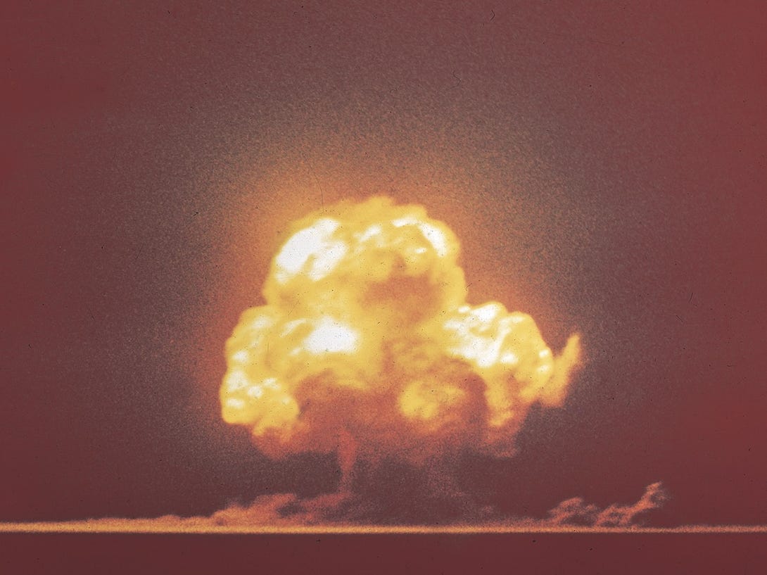 Trinity-Atombombentest in der Ferne, gelber Atompilz, der in den orangefarbenen Himmel ausbricht
