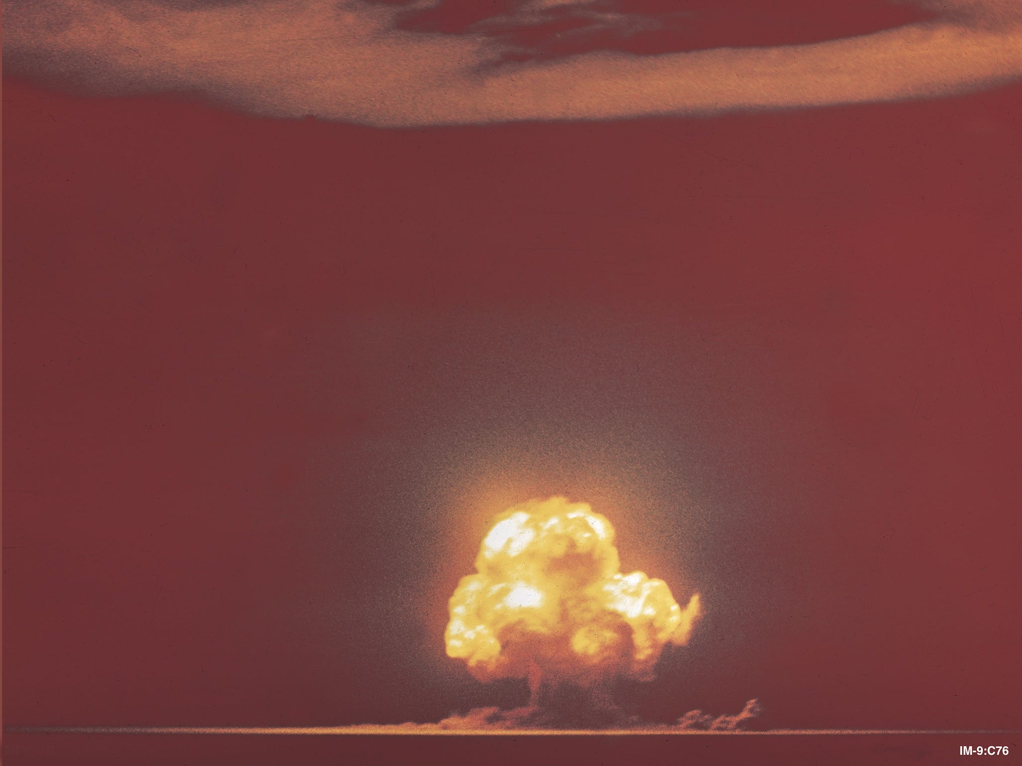 Trinity-Atombombentest in der Ferne, gelber Atompilz, der in den orangefarbenen Himmel ausbricht
