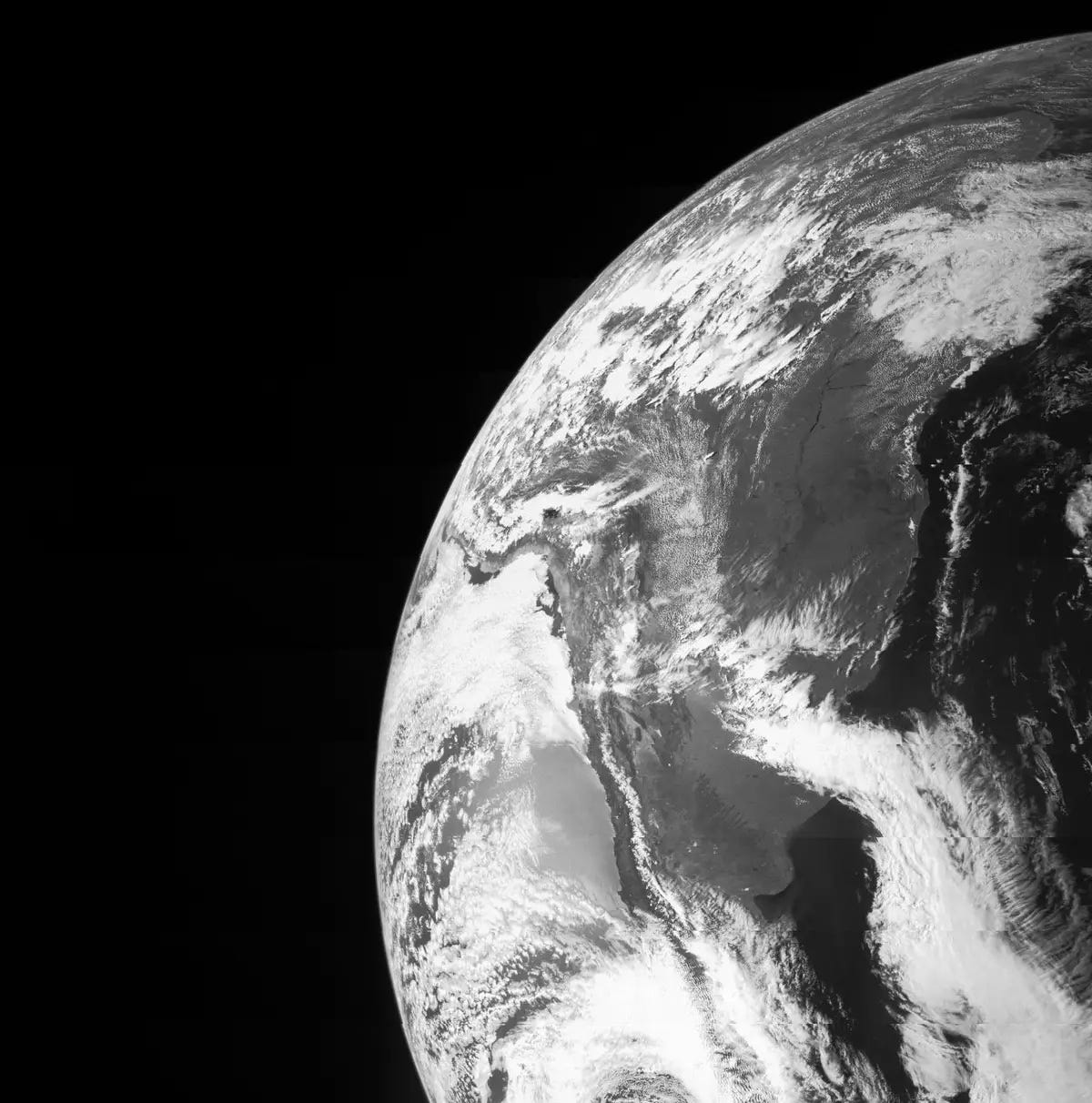 Schwarz-Weiß-Foto der Erde vor der Dunkelheit des Weltraums.