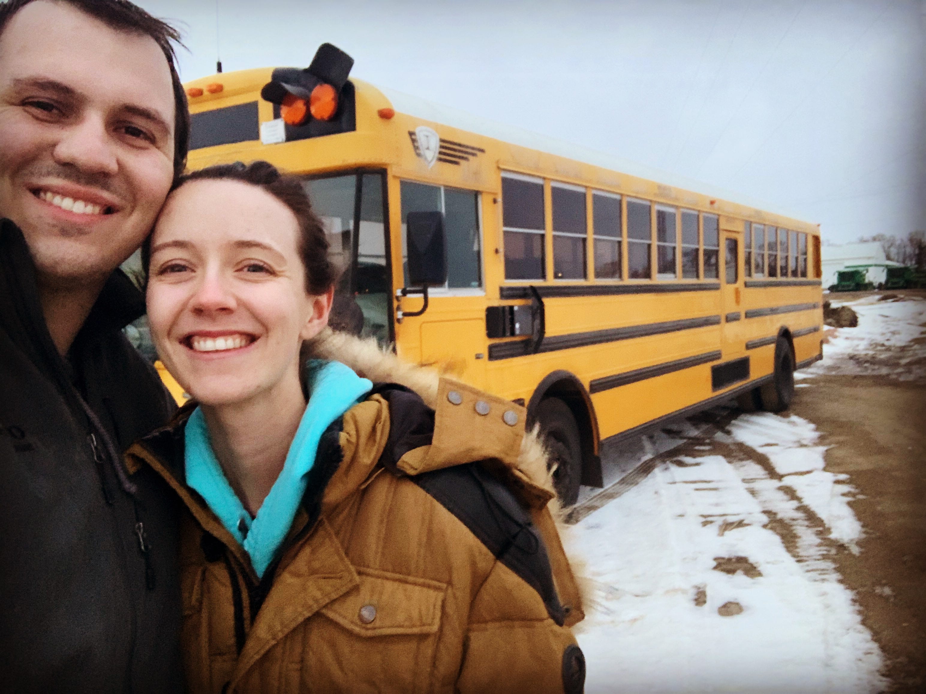 Ein Paar macht ein Selfie mit einem Schulbus