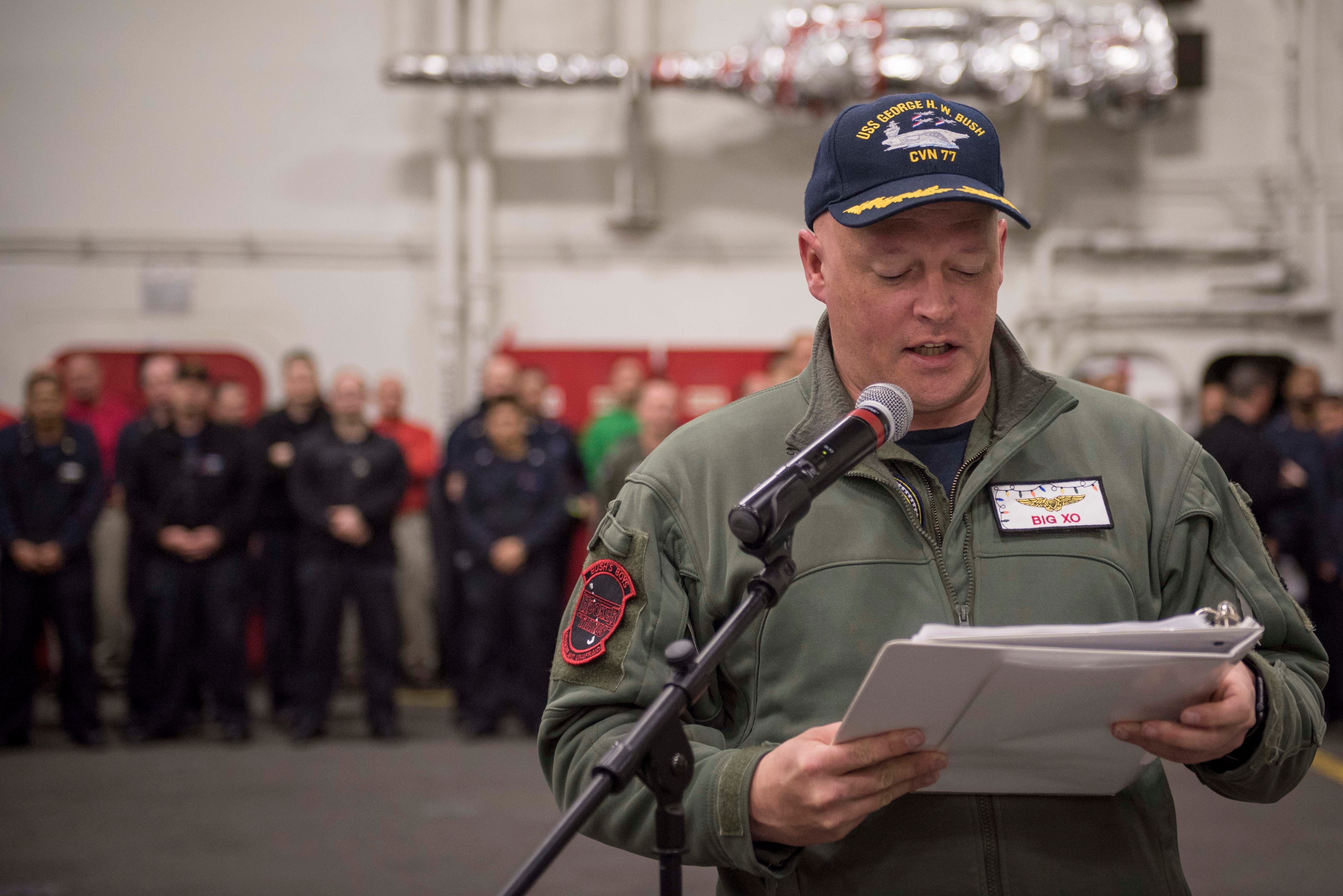 Kapitän Chris Hill gibt die Namen der beförderten Matrosen während einer Zeremonie an Bord der USS George HW Bush im Dezember 2017 bekannt.
