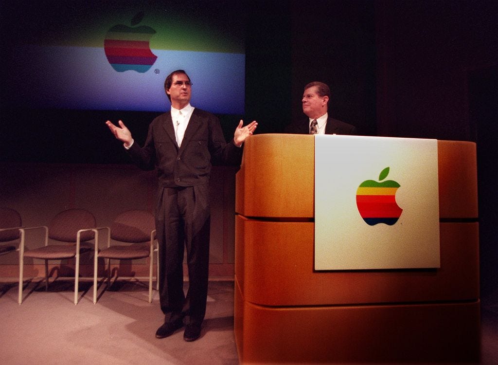 Der ehemalige Apple-CEO Gilbert R. Amelio (r.) und Apple-Mitbegründer Steve Jobs auf der Bühne im Jahr 1996.